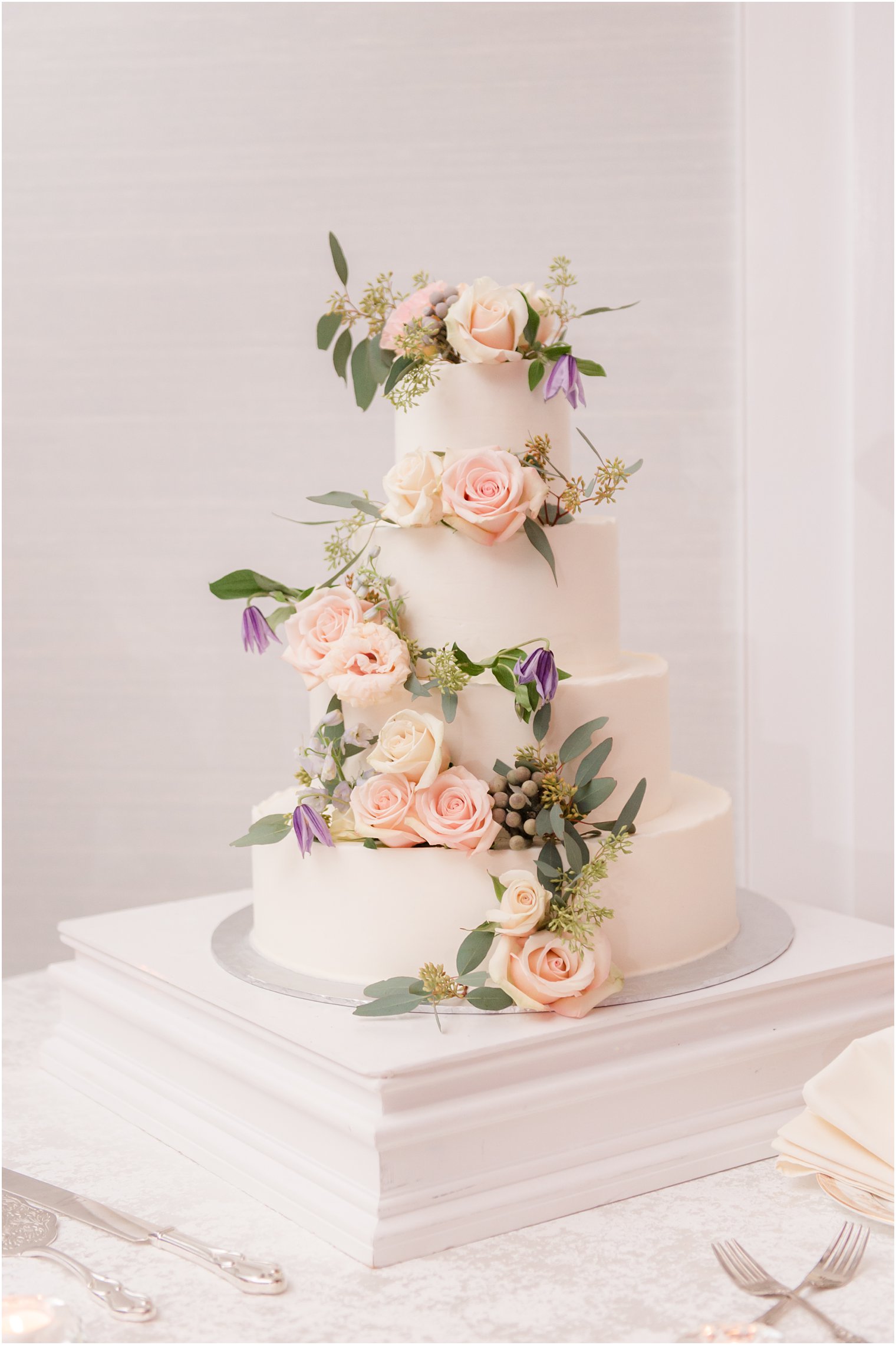 tiered wedding cake with pastel flowers at the Mill Lakeside Manor