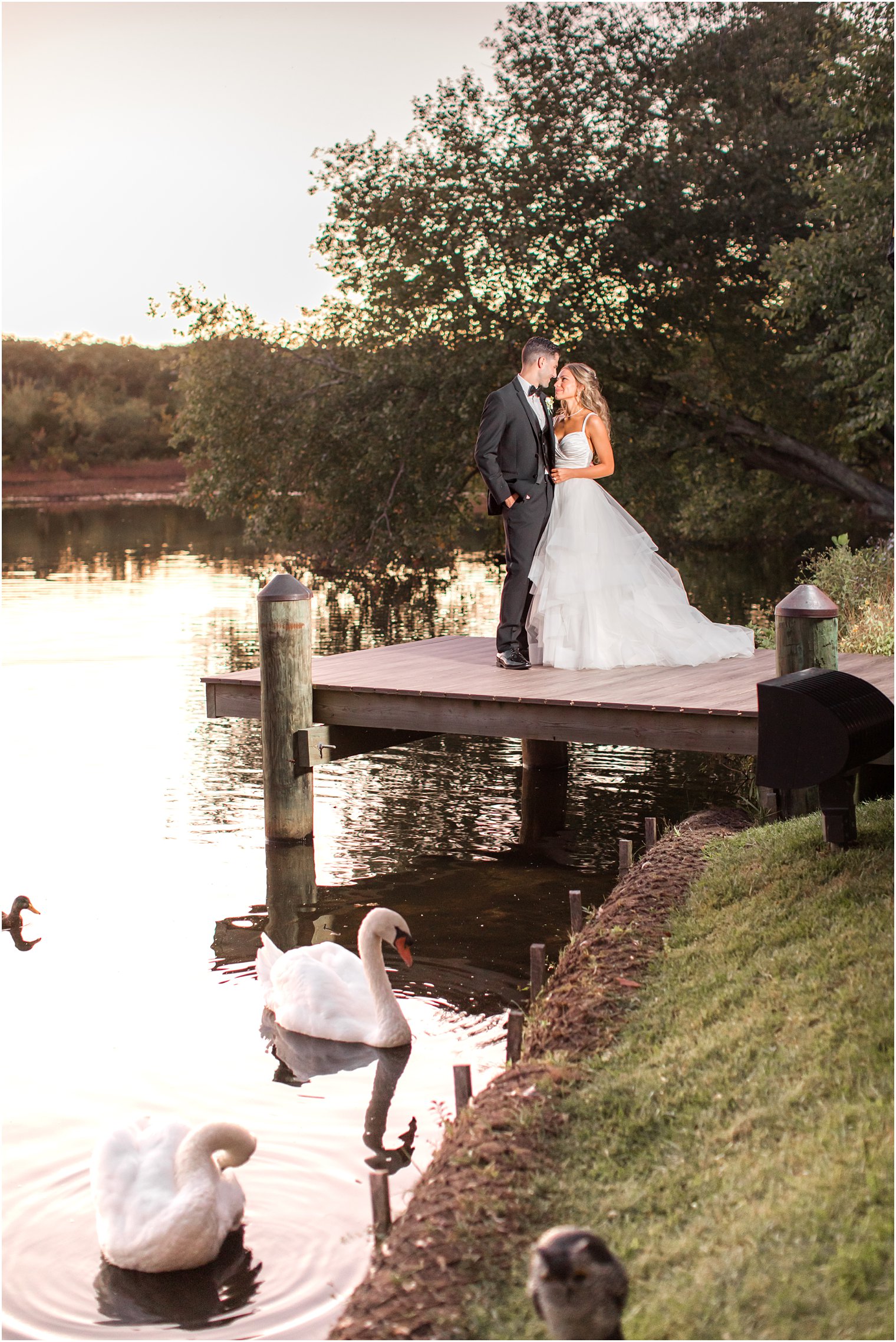 bride and groom pose on dock at the Mill Lakeside Manor