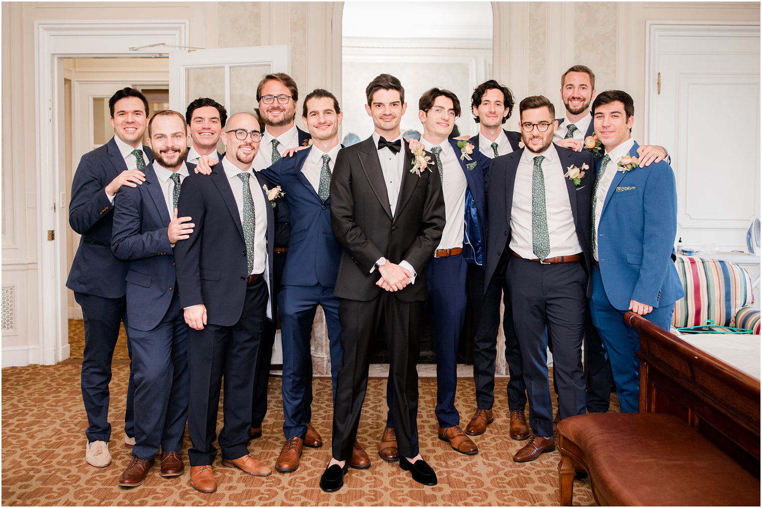 groom poses with groomsmen before NY wedding