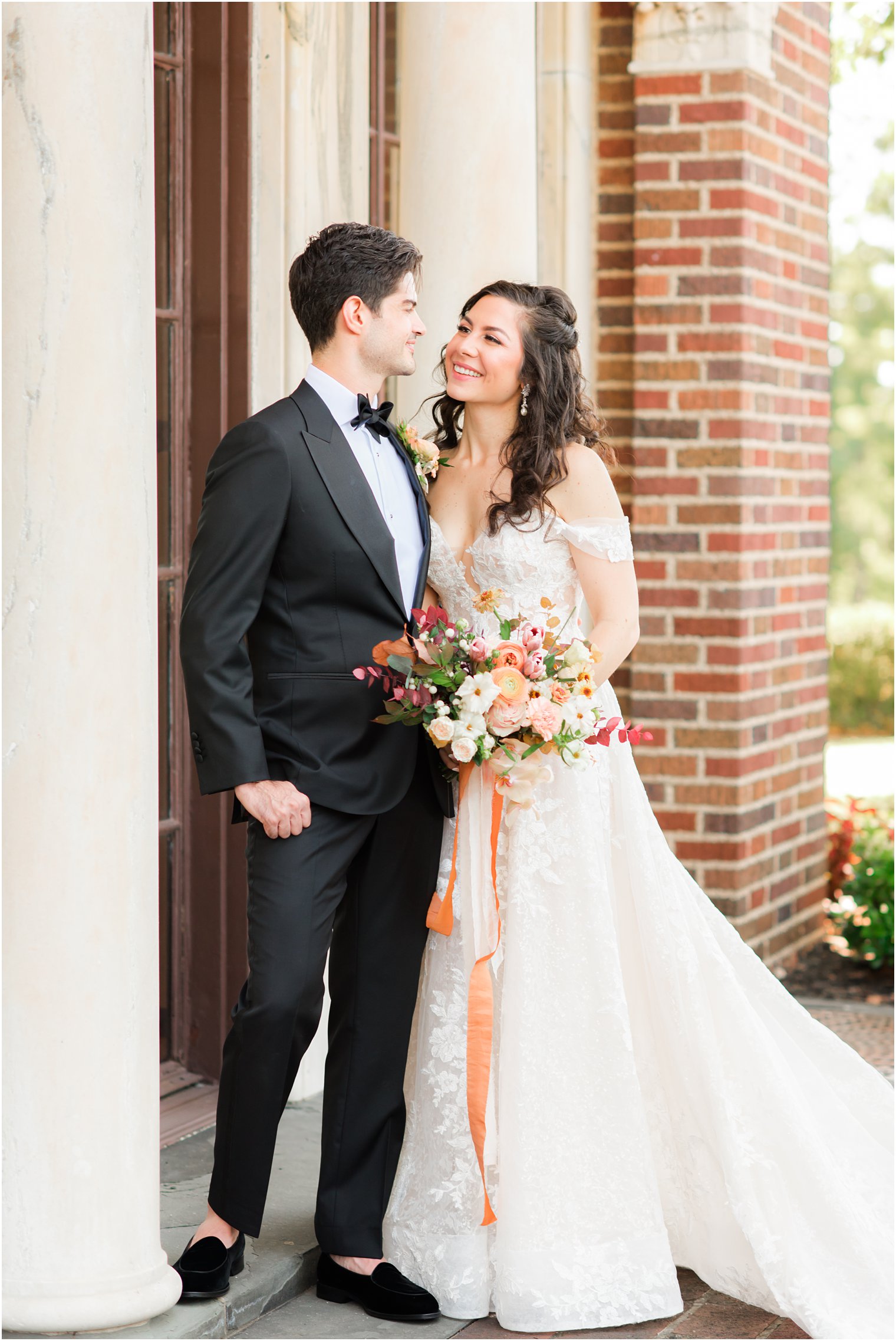 bride and groom pose outside the Village Club of Sands Point