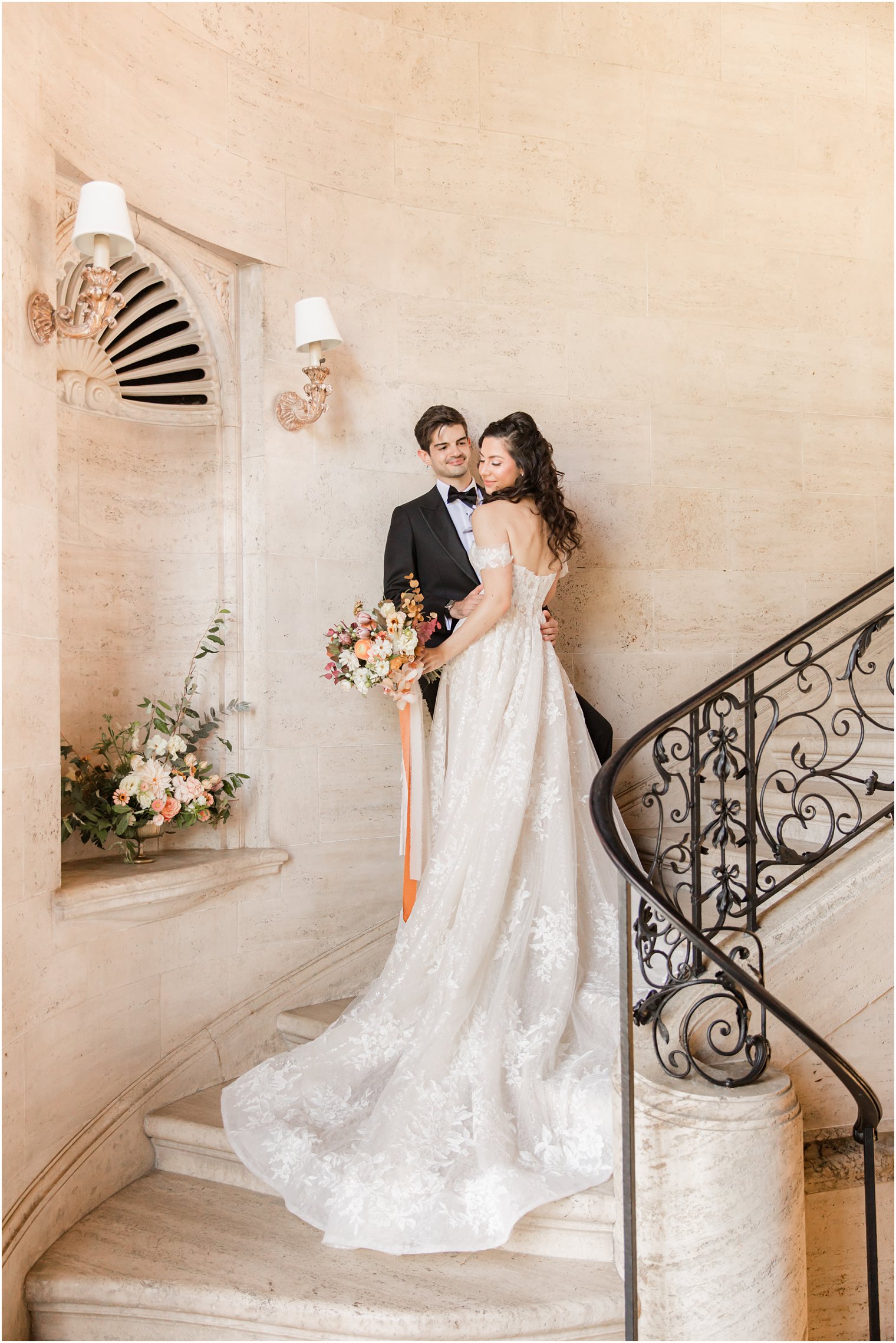 newlyweds pose on staircase in Sands Point NY