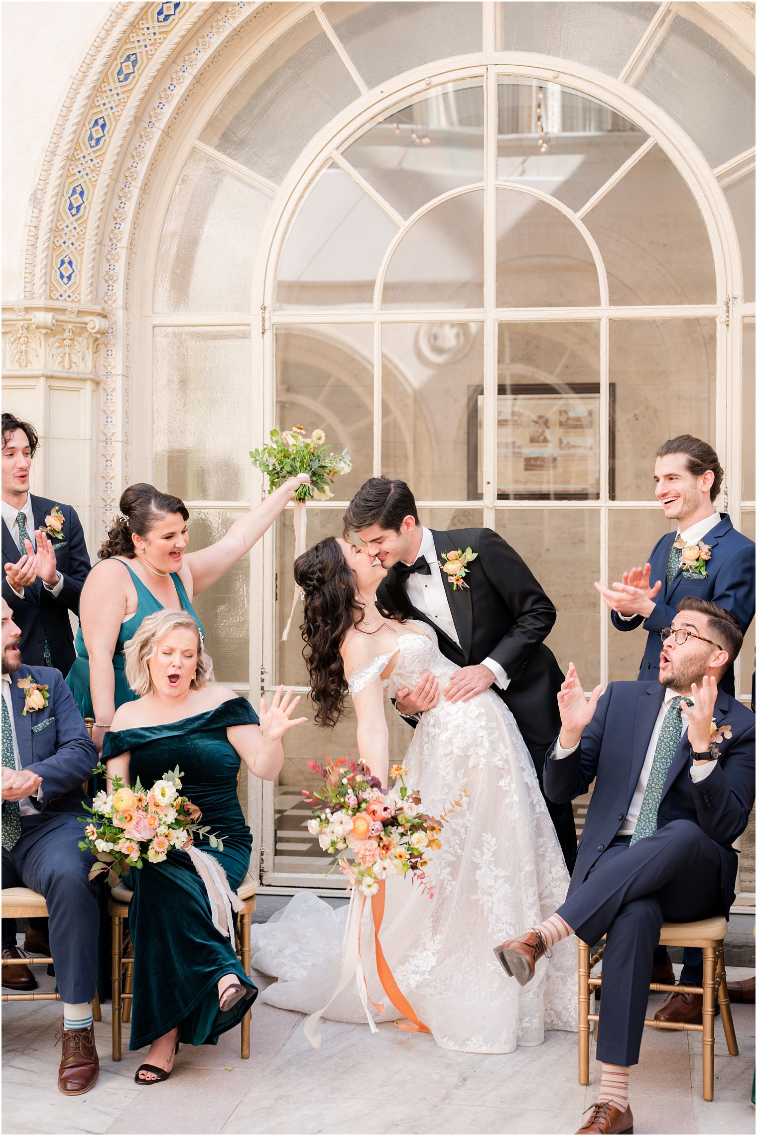 newlyweds kiss while bridal party cheers