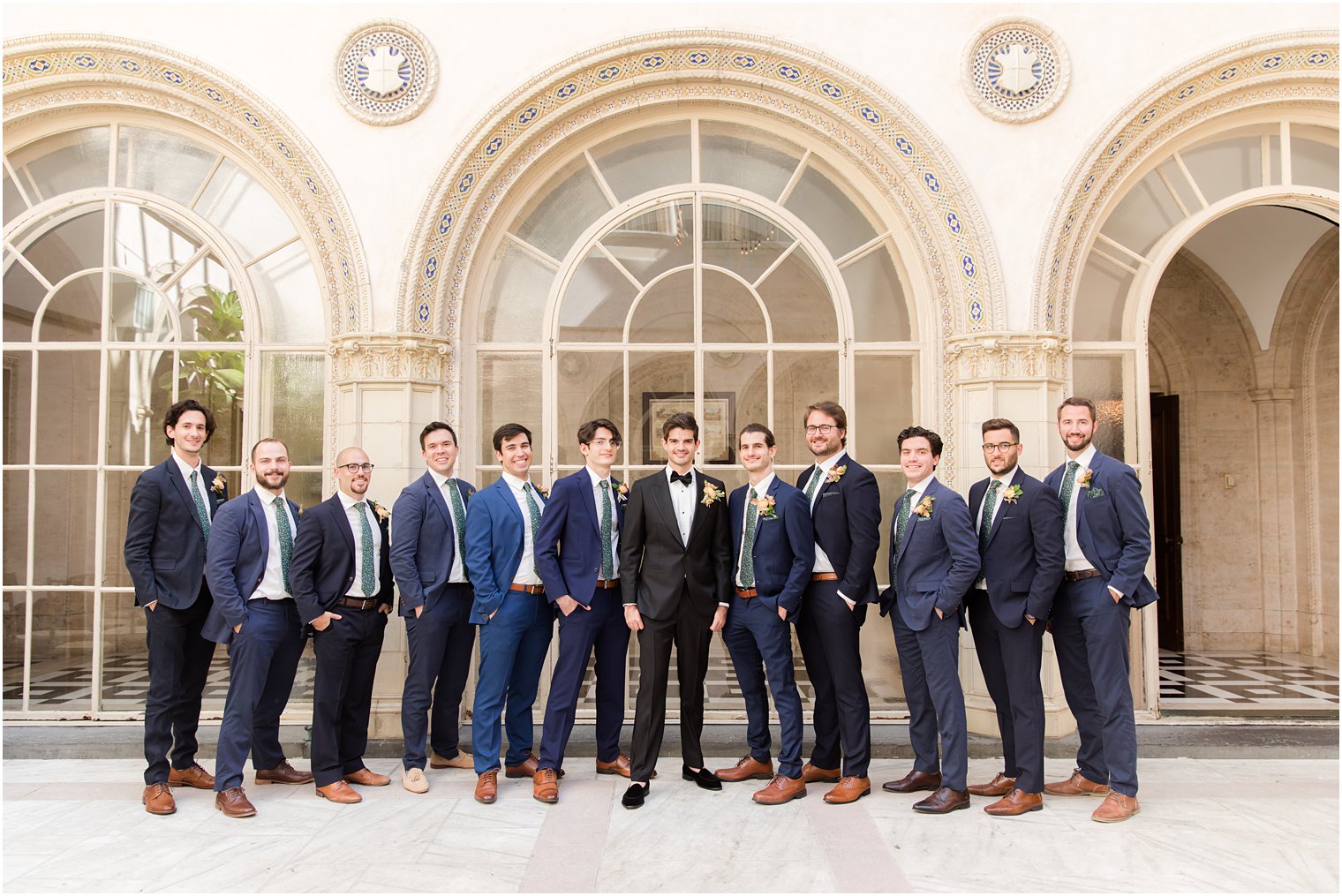 groom and groomsmen pose in mismatched navy suits