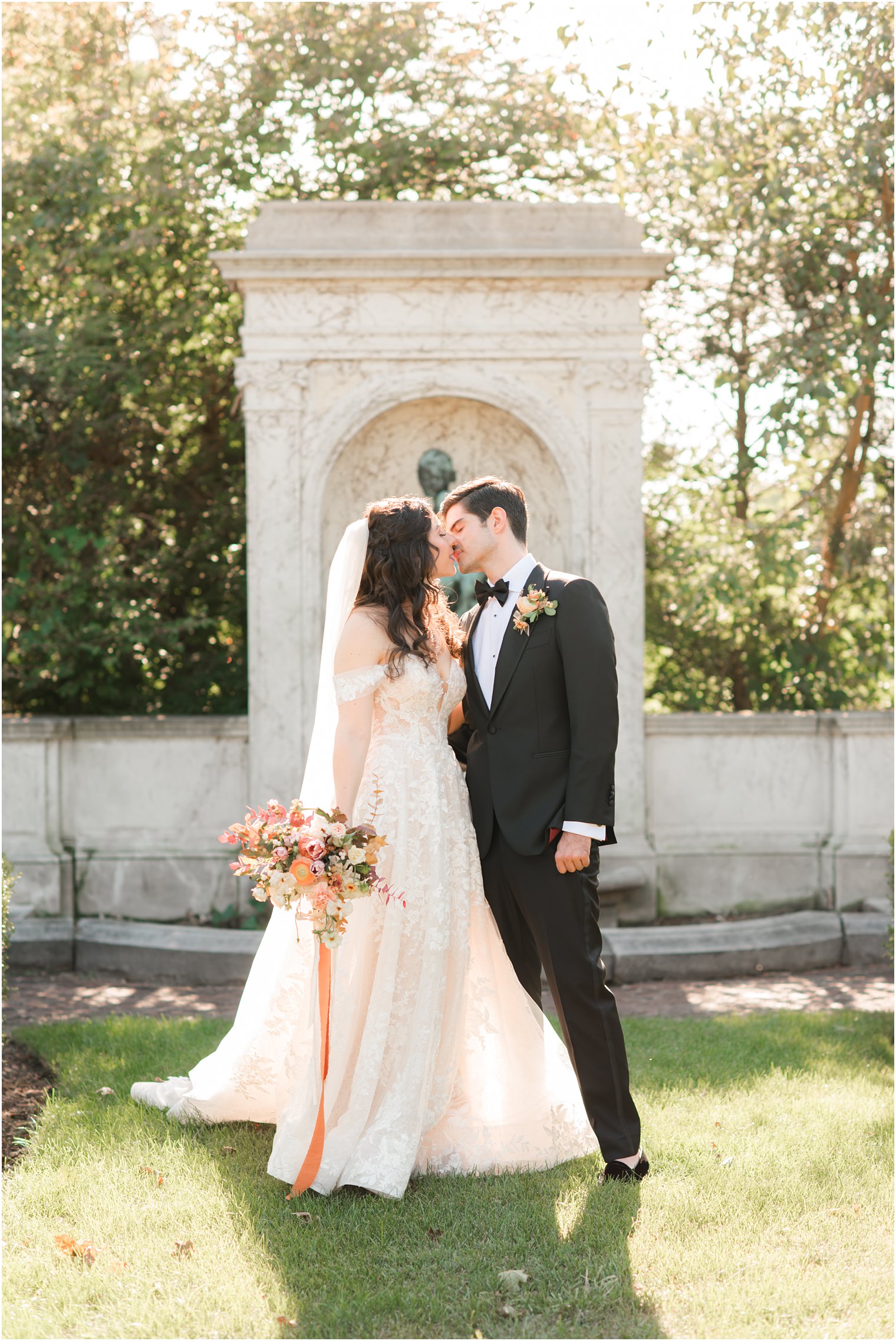 bride and groom kiss in New York garden on wedding day