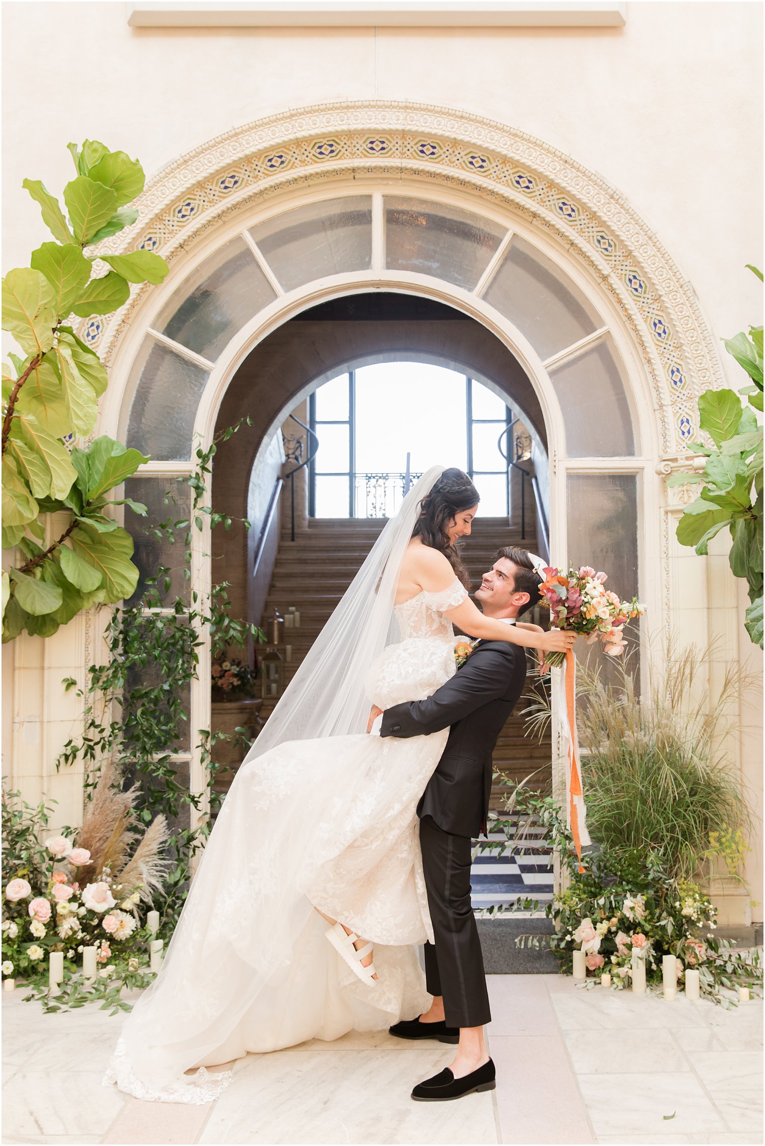 groom lifts bride during NY wedding portraits