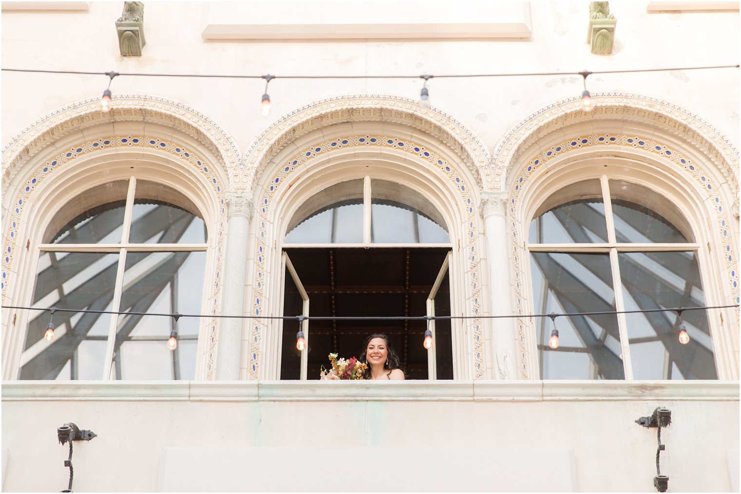 bride looks out balcony window at the Village Club of Sands Point