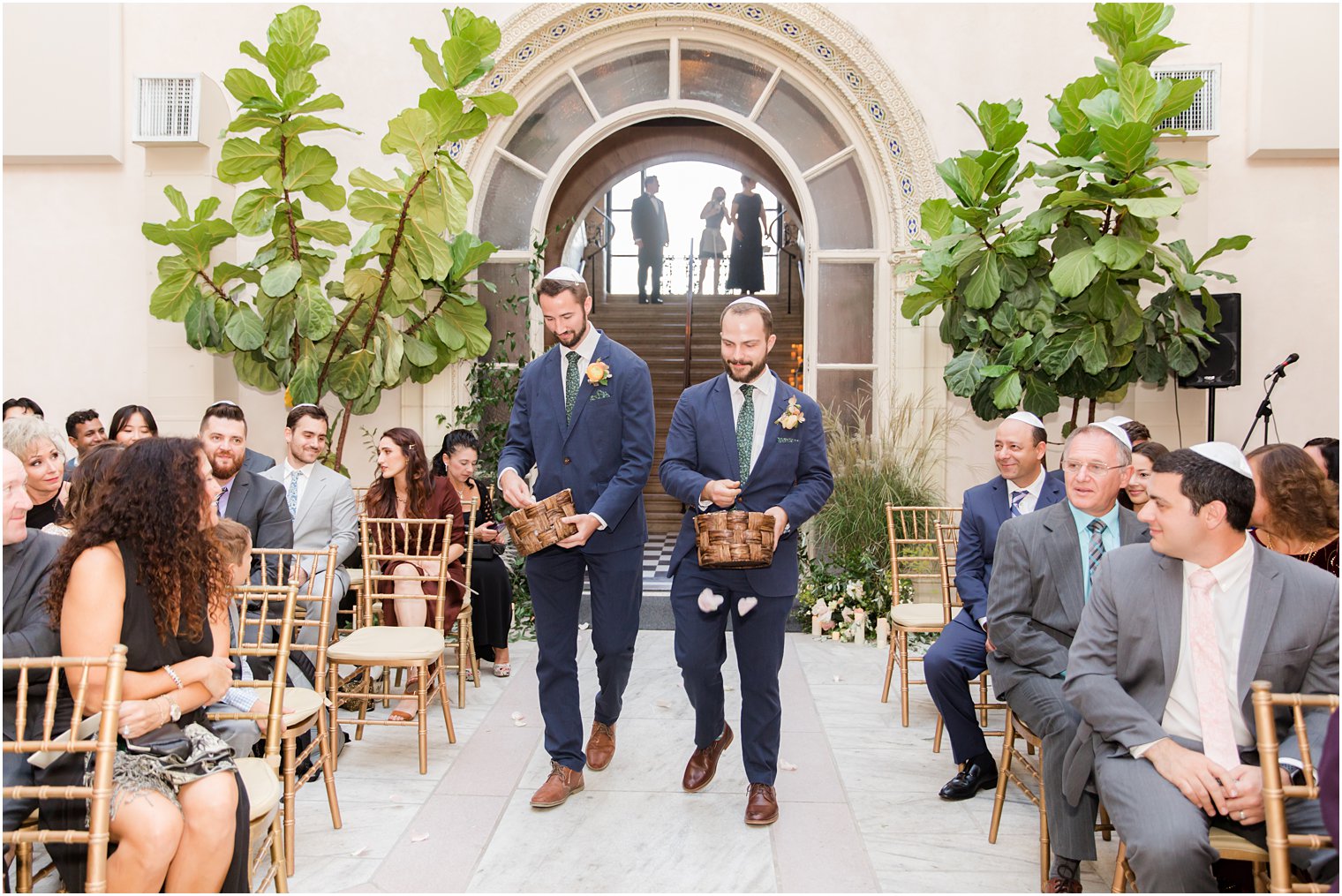 groomsmen walk down throwing flowers