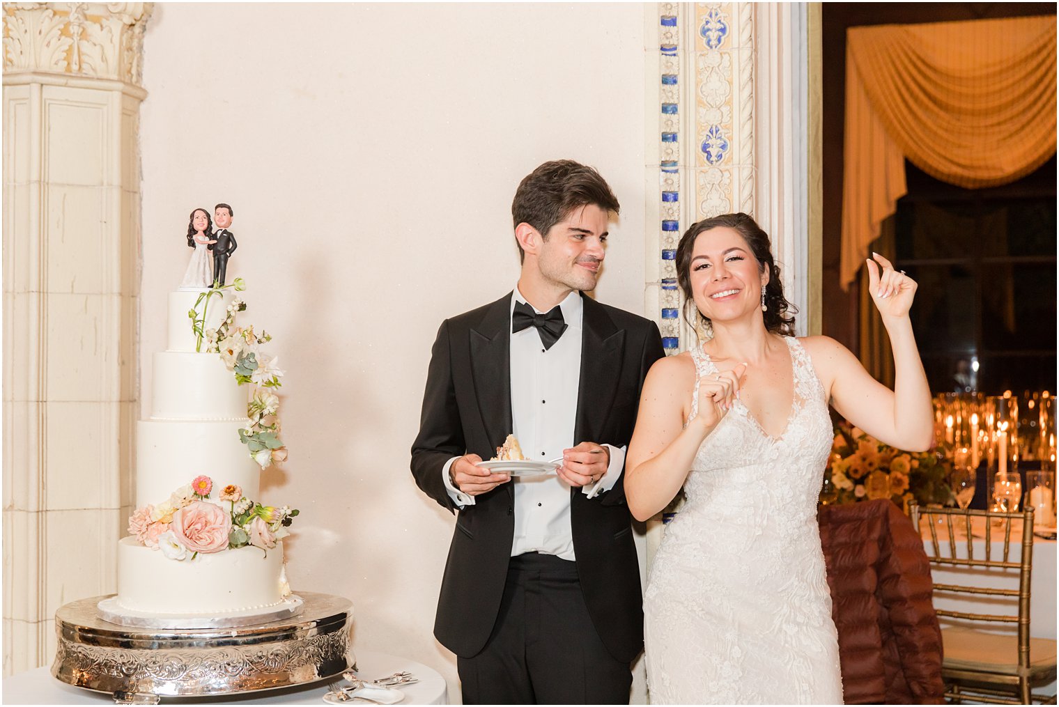 newlyweds dance by wedding cake during Sands Point NY wedding reception