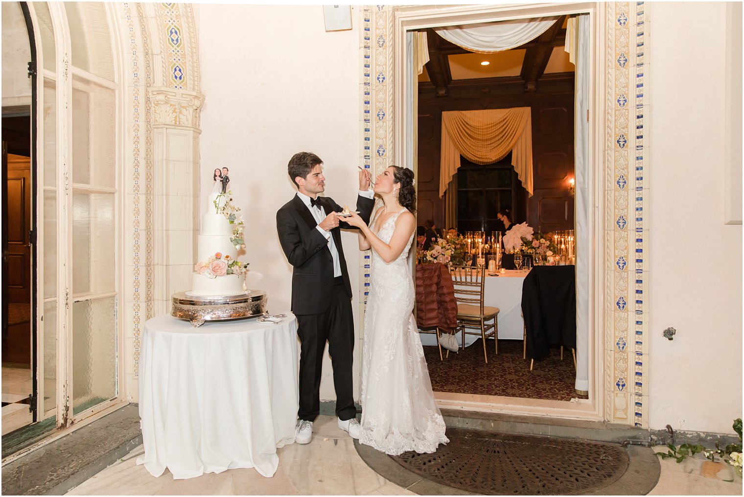 groom feeds bride cake during Village Club of Sands Point Wedding reception 