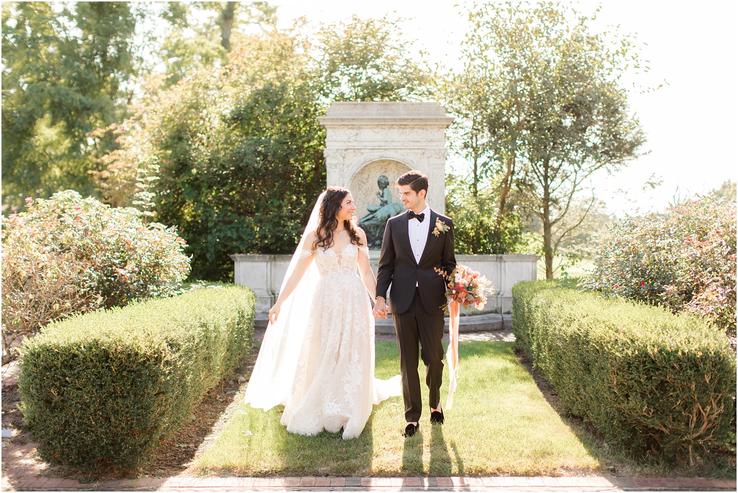newlyweds walk through gardens at the Village Club of Sands Point