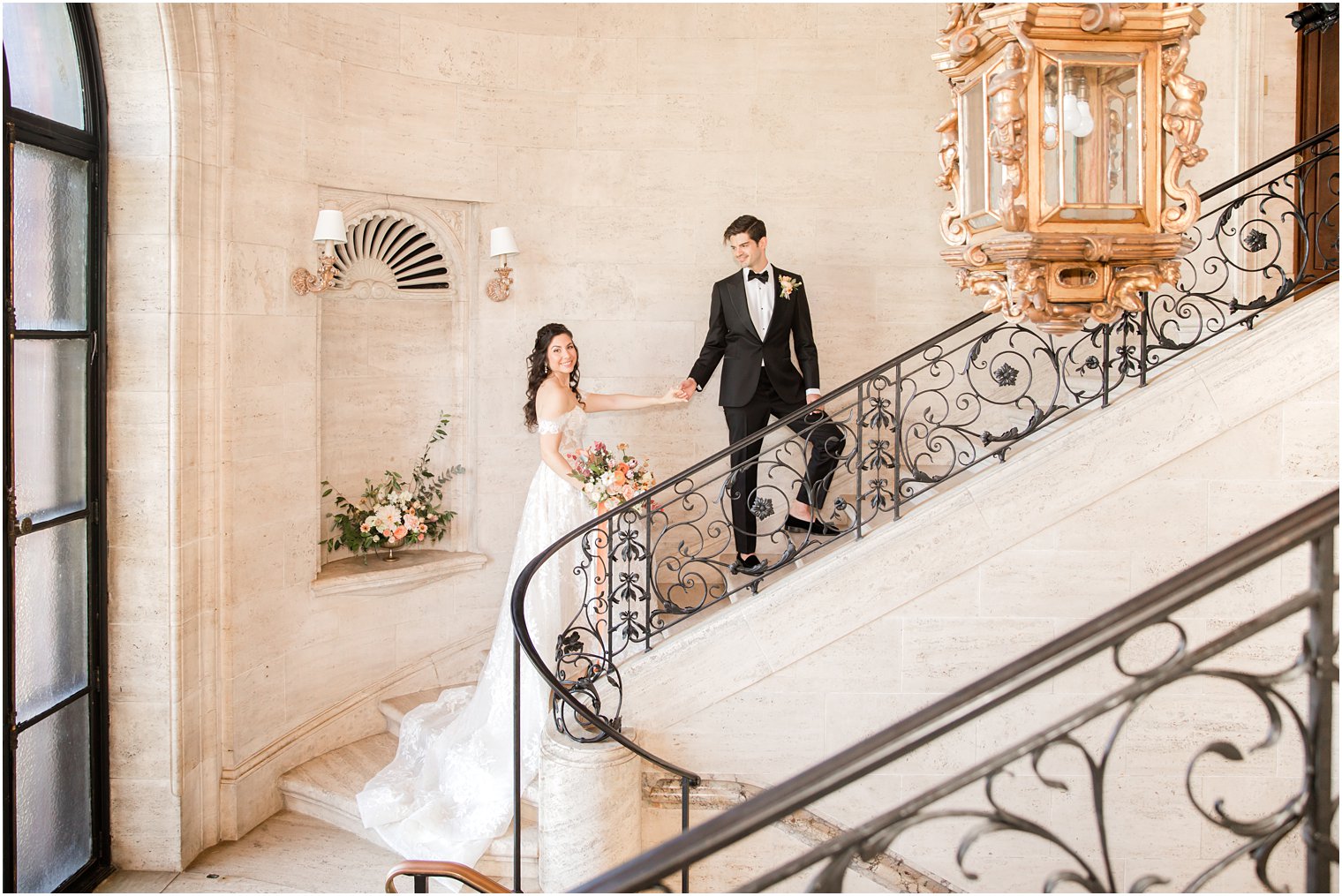 groom leads bride up staircase at the Village Club of Sands Point
