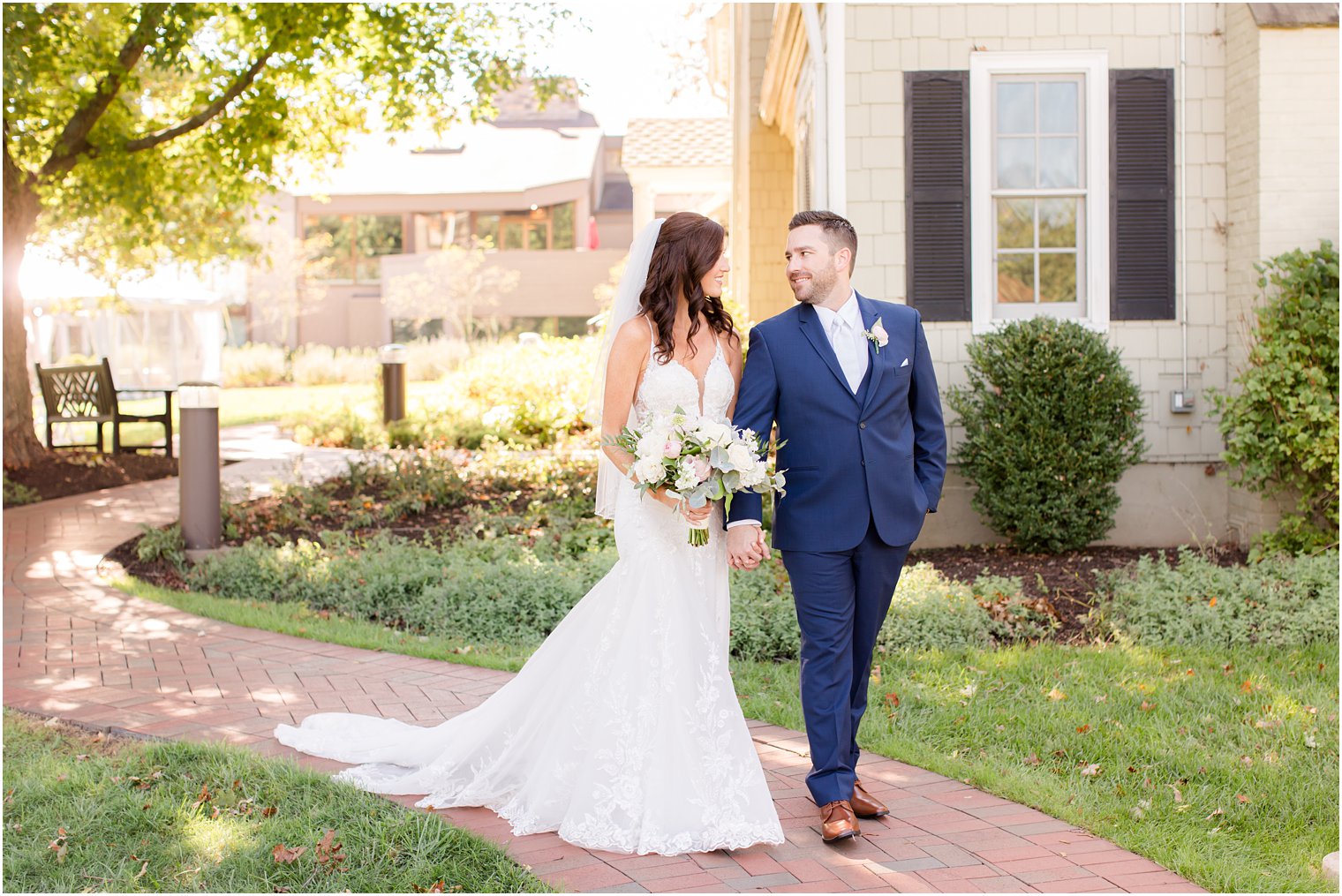 newlyweds hold hands looking at each other walking through the Chauncey Hotel