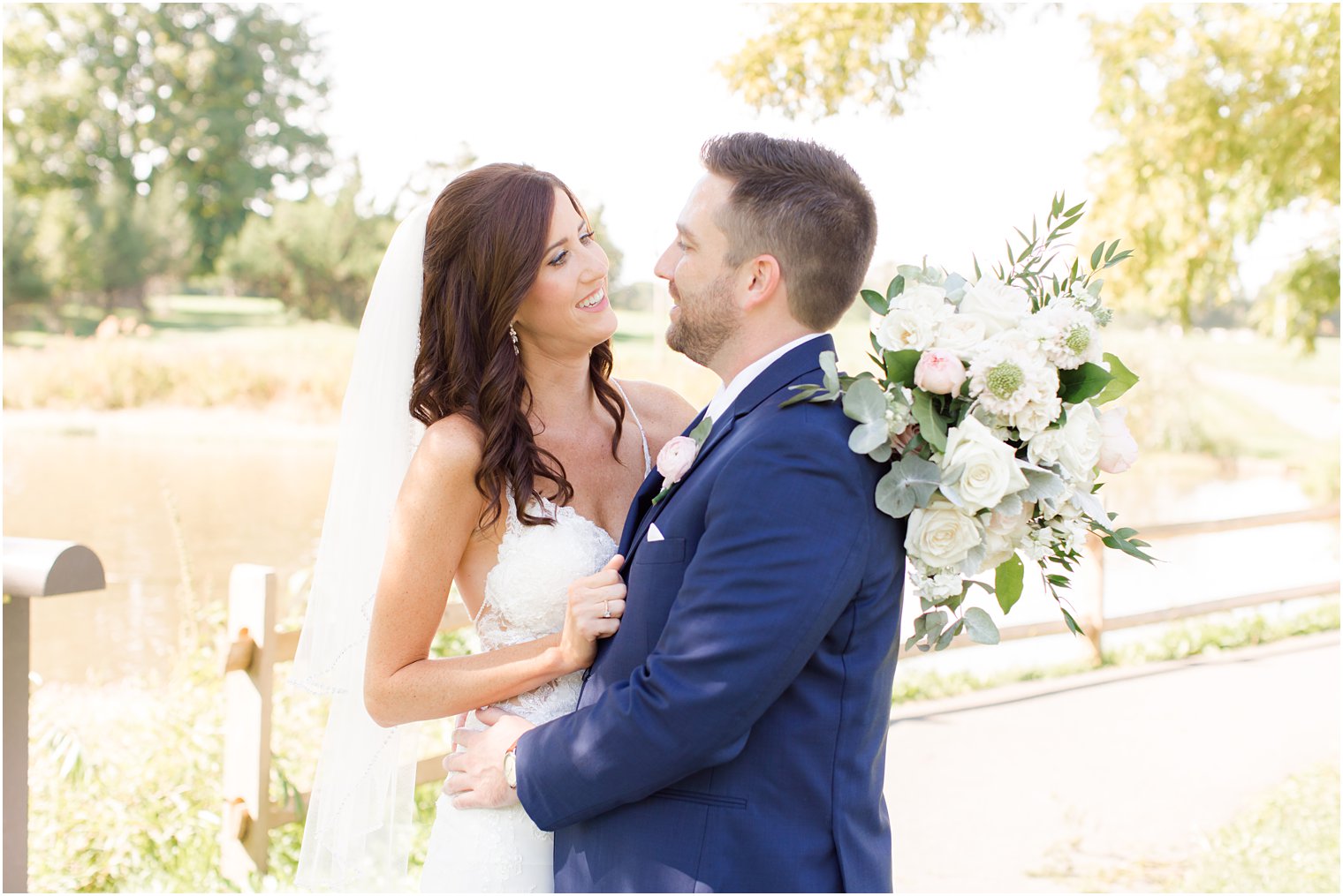 bride smiles at groom holding bouquet behind his head during Chauncey Hotel wedding portraits 