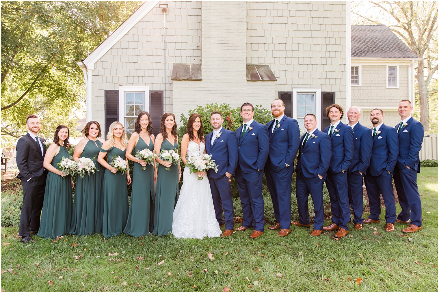 wedding party in blue and green stands alongside the Chauncey Hotel