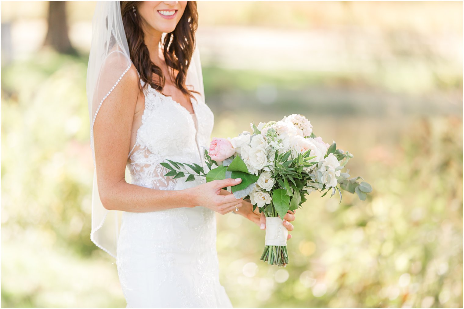 bride holds bouquet of ivory and pink flowers for Chauncey Hotel wedding day 