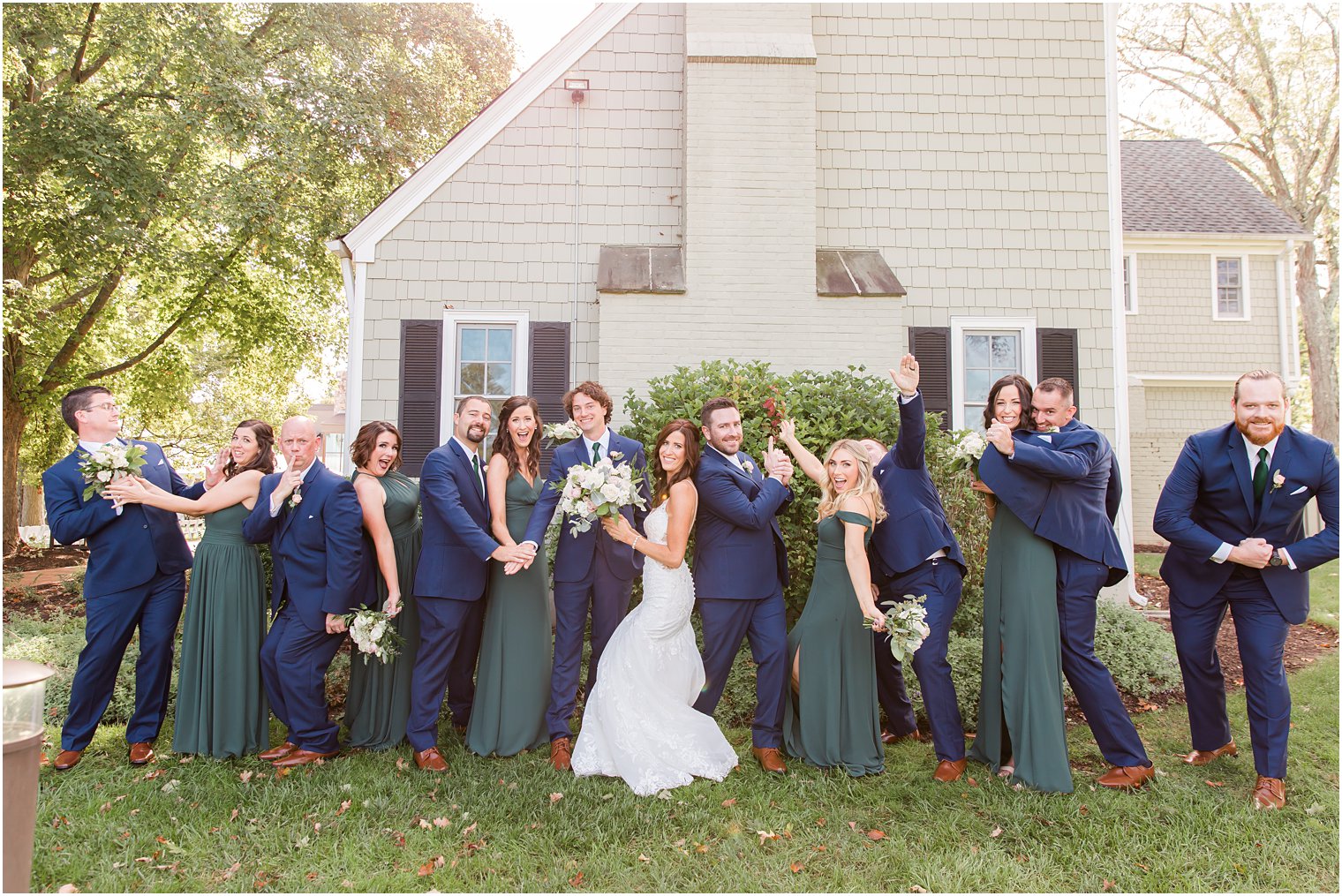 bridal party strikes funny pose during portraits with bride and groom 