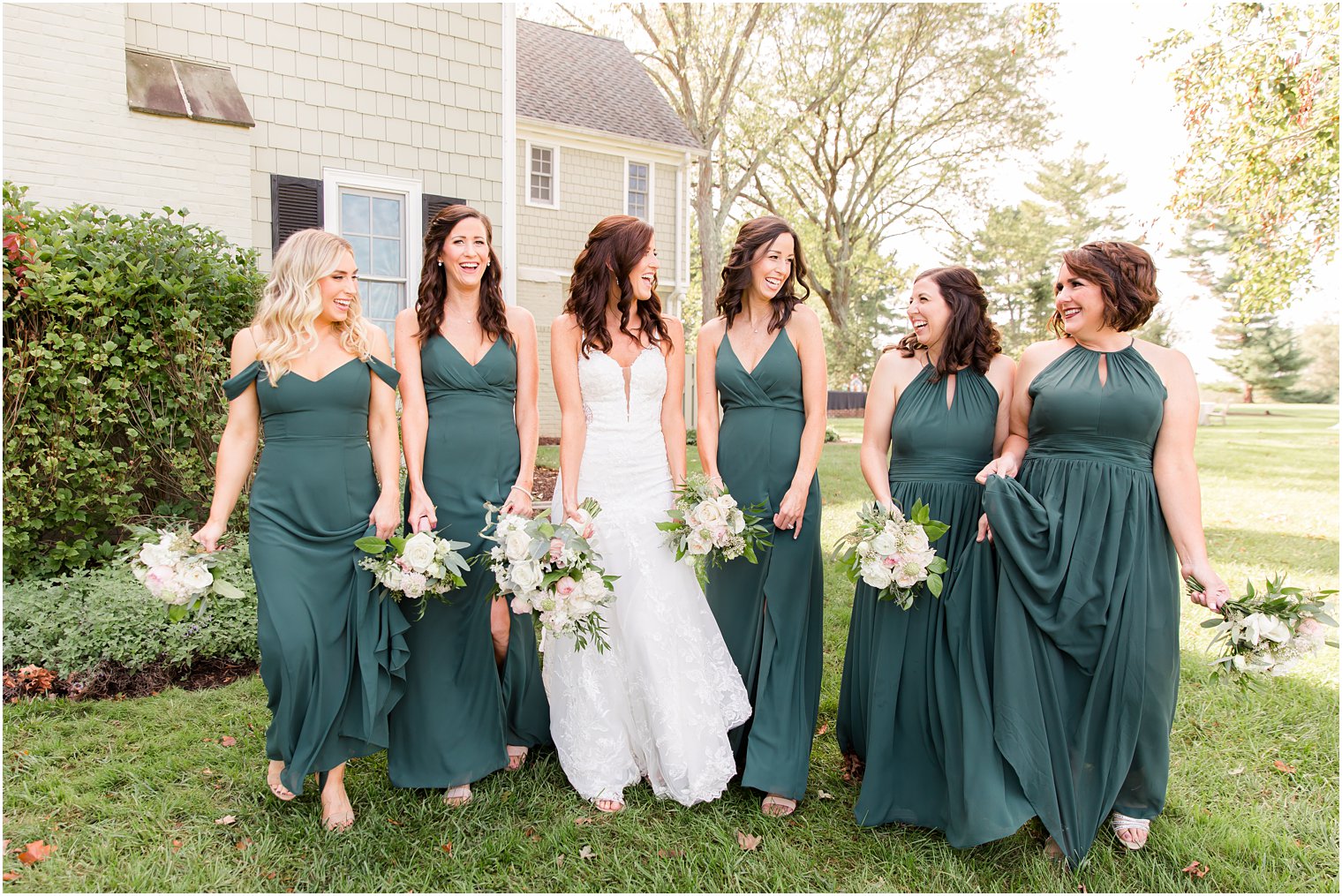 bridesmaids in green gowns walk with bride at Chauncey Hotel