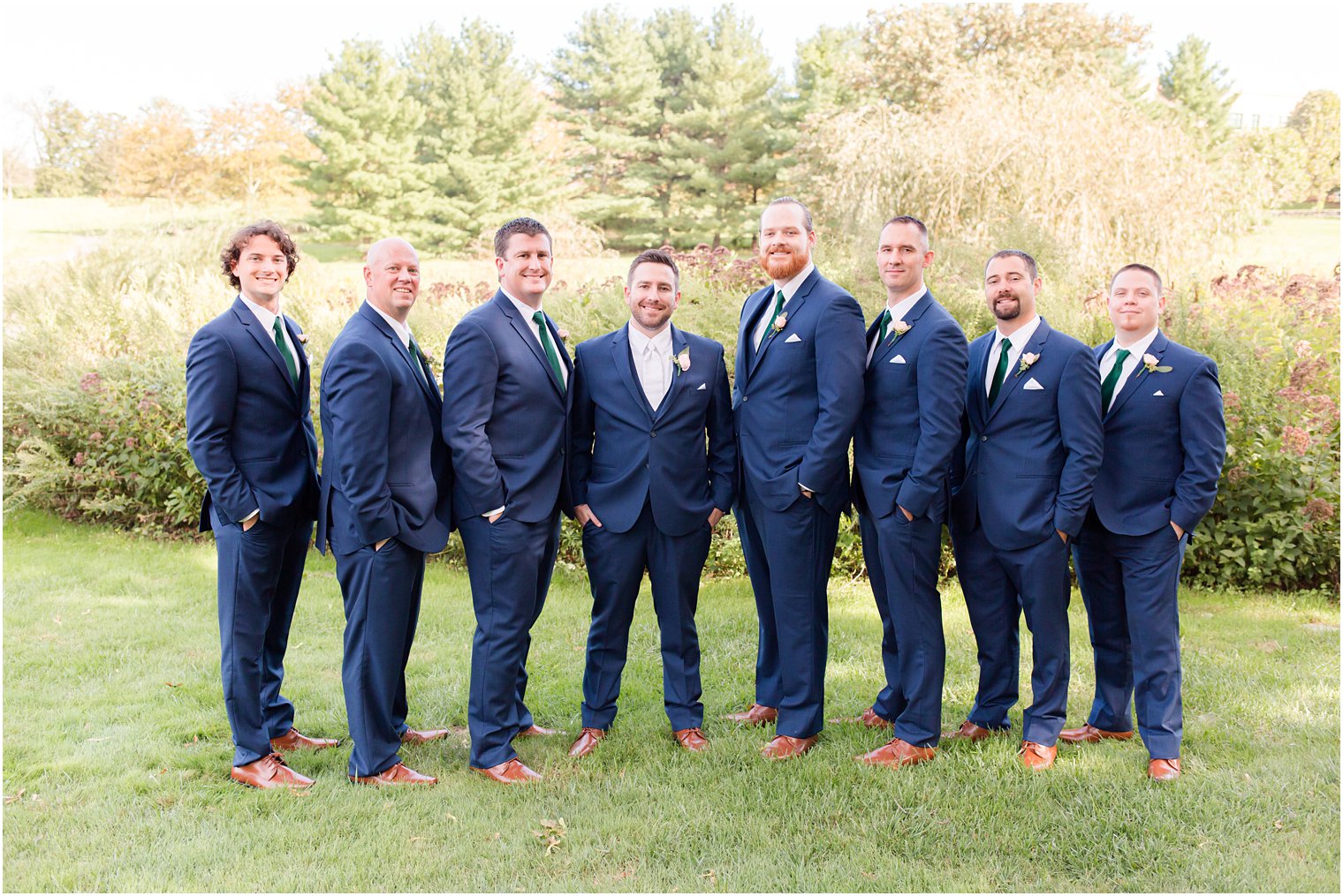 groom stands with groomsmen in navy suits for fall wedding in Princeton NJ 