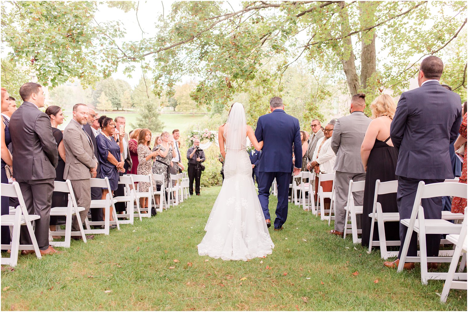 bride walks down aisle with dad outside at the Chauncey Hotel