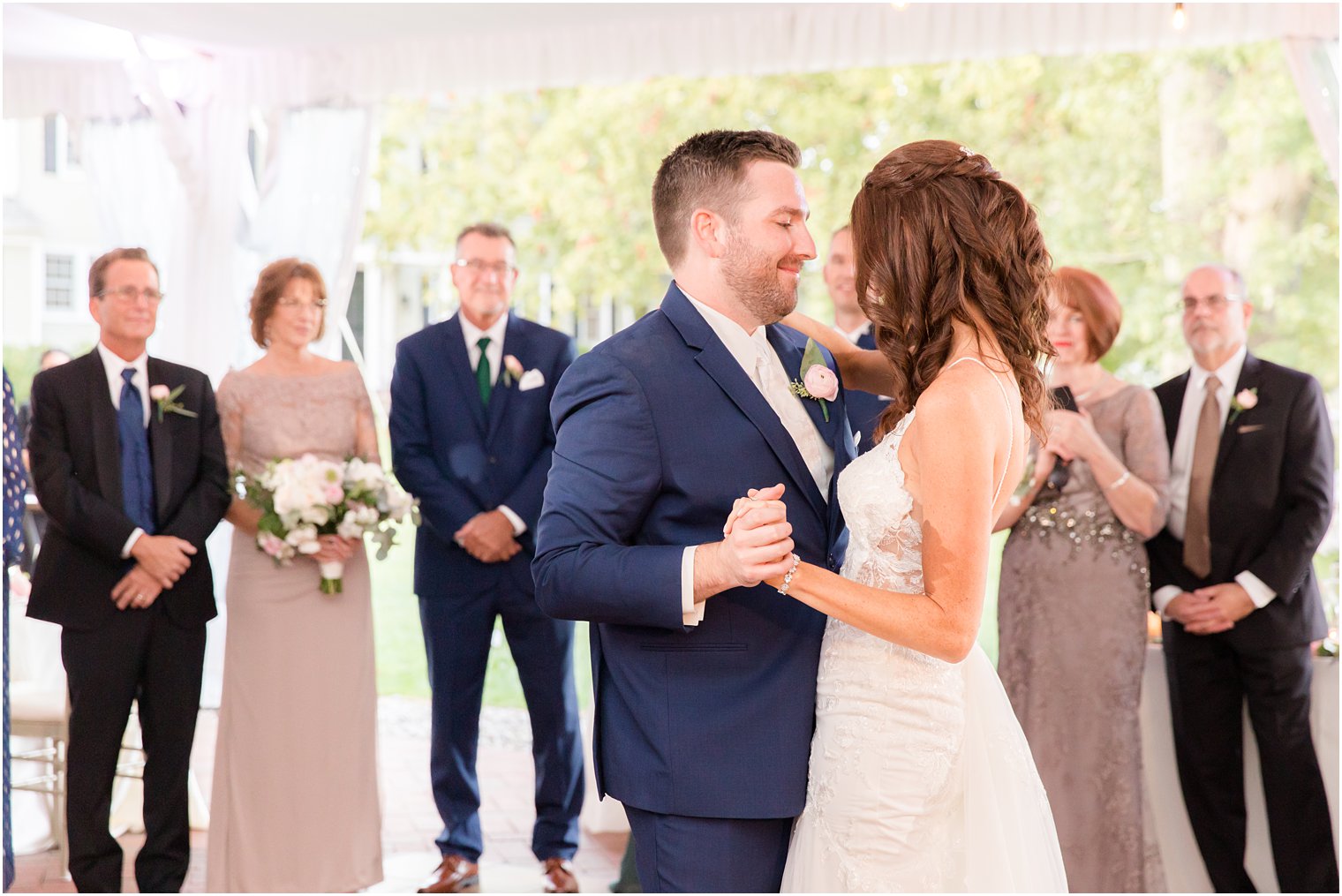 groom smiles at bride during first dance during tented Princeton NJ wedding reception