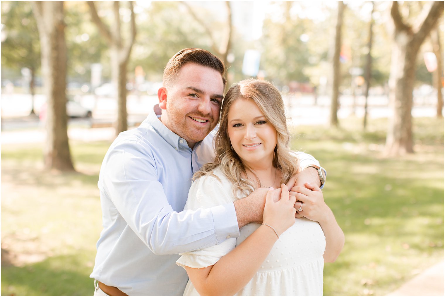 groom hugs bride from behind during Rodin Museum engagement session