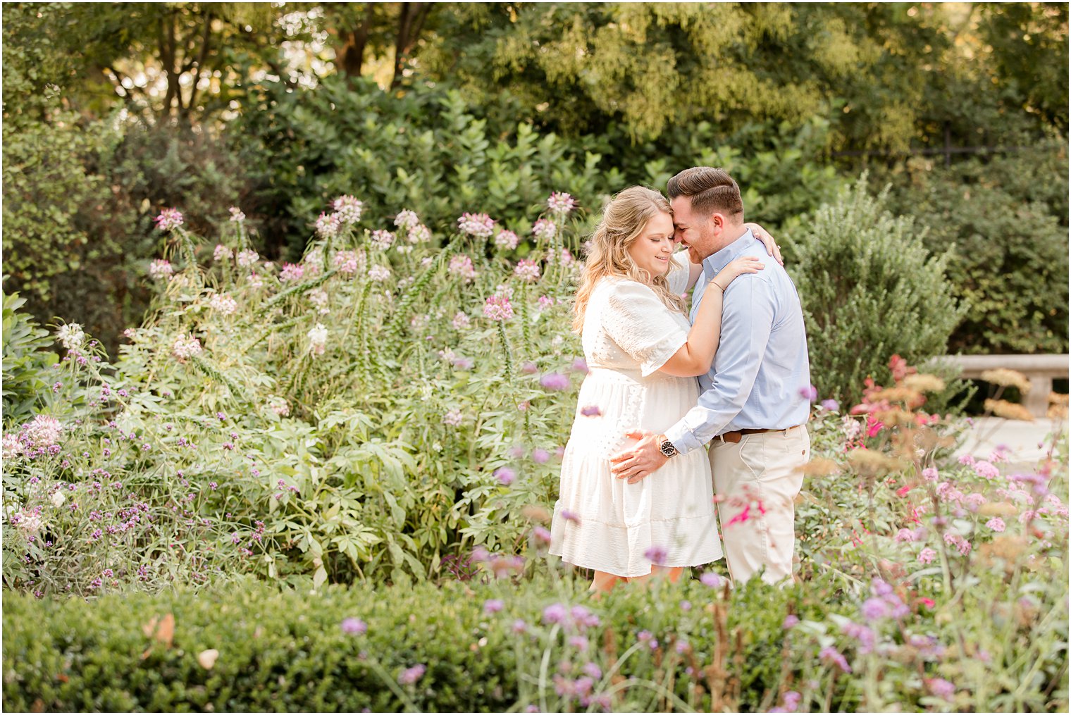 bride and groom hug in garden with purple flowers during Rodin Museum engagement session
