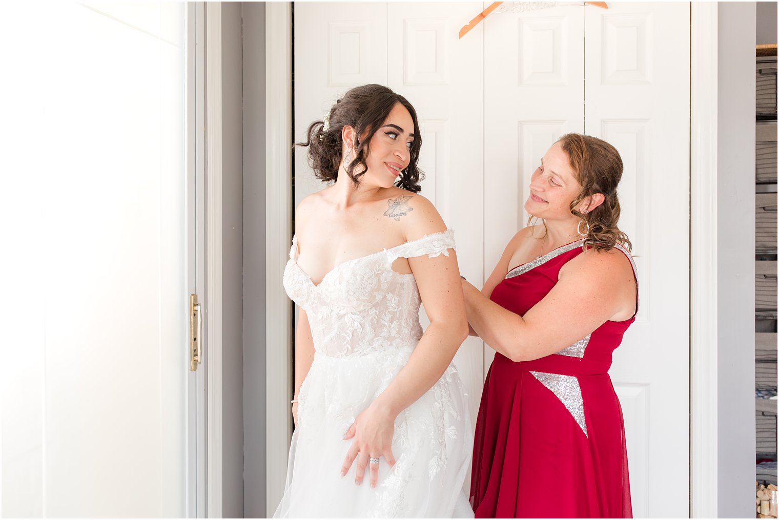 bride looks over shoulder at mother during wedding prep