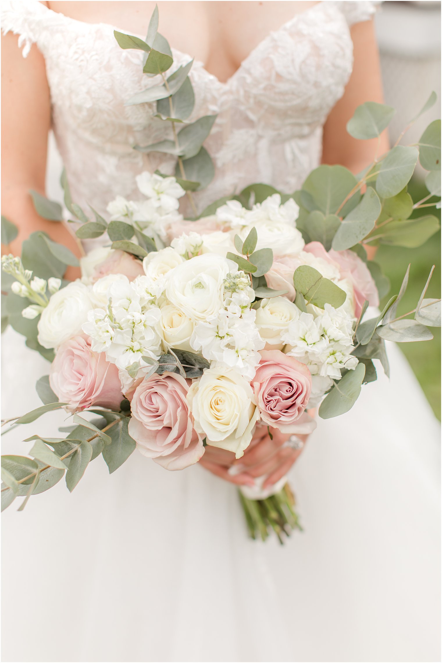 bride holds bouquet of pink and ivory roses for NJ wedding