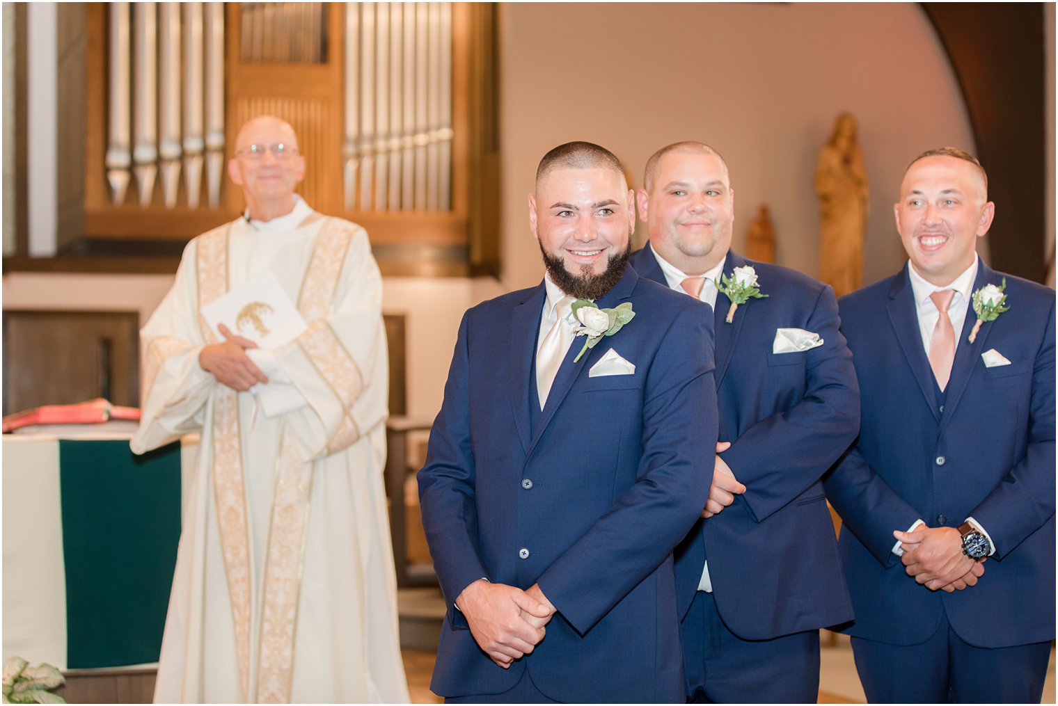 groom smiles looking at bride during traditional wedding ceremony at Saint Matthew the Apostle church