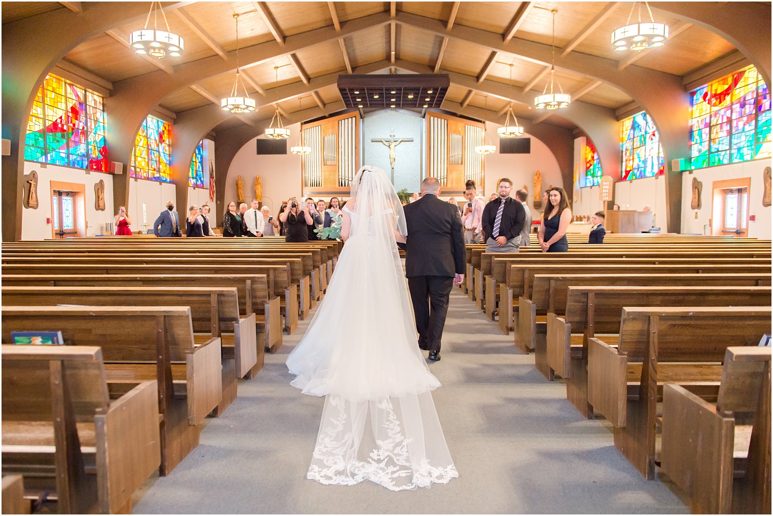 bride walks down aisle with dad for traditional wedding ceremony at Saint Matthew the Apostle church