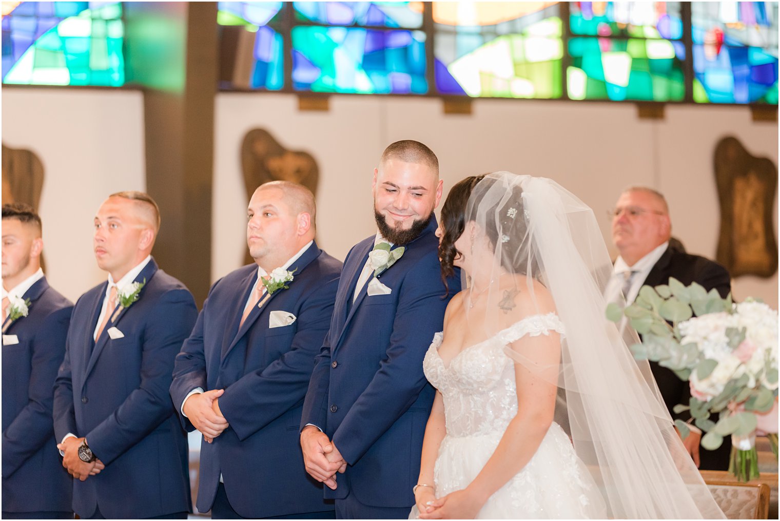 bride and groom smile together during traditional wedding ceremony at Saint Matthew the Apostle church
