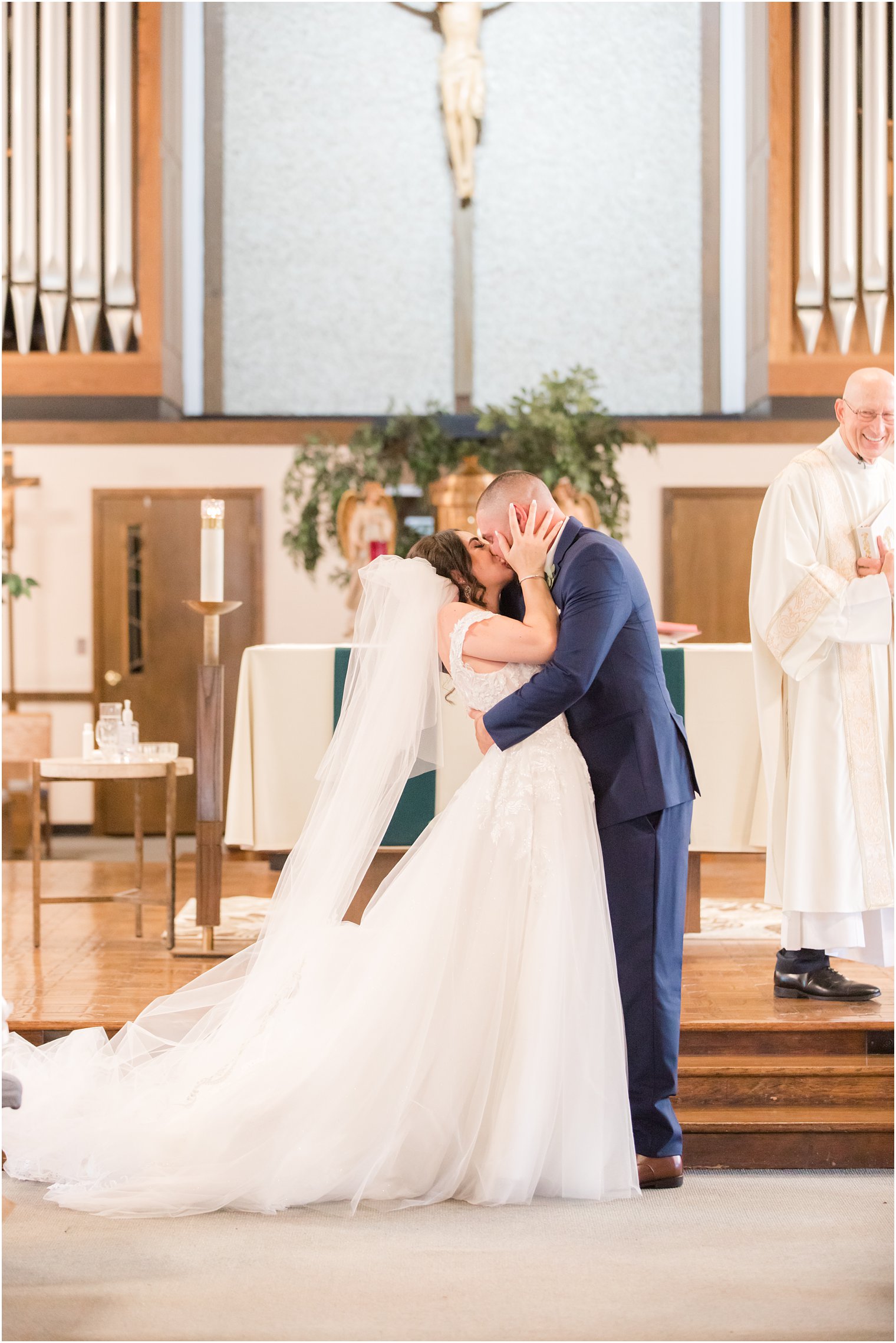 couple kisses during traditional wedding ceremony at Saint Matthew the Apostle church