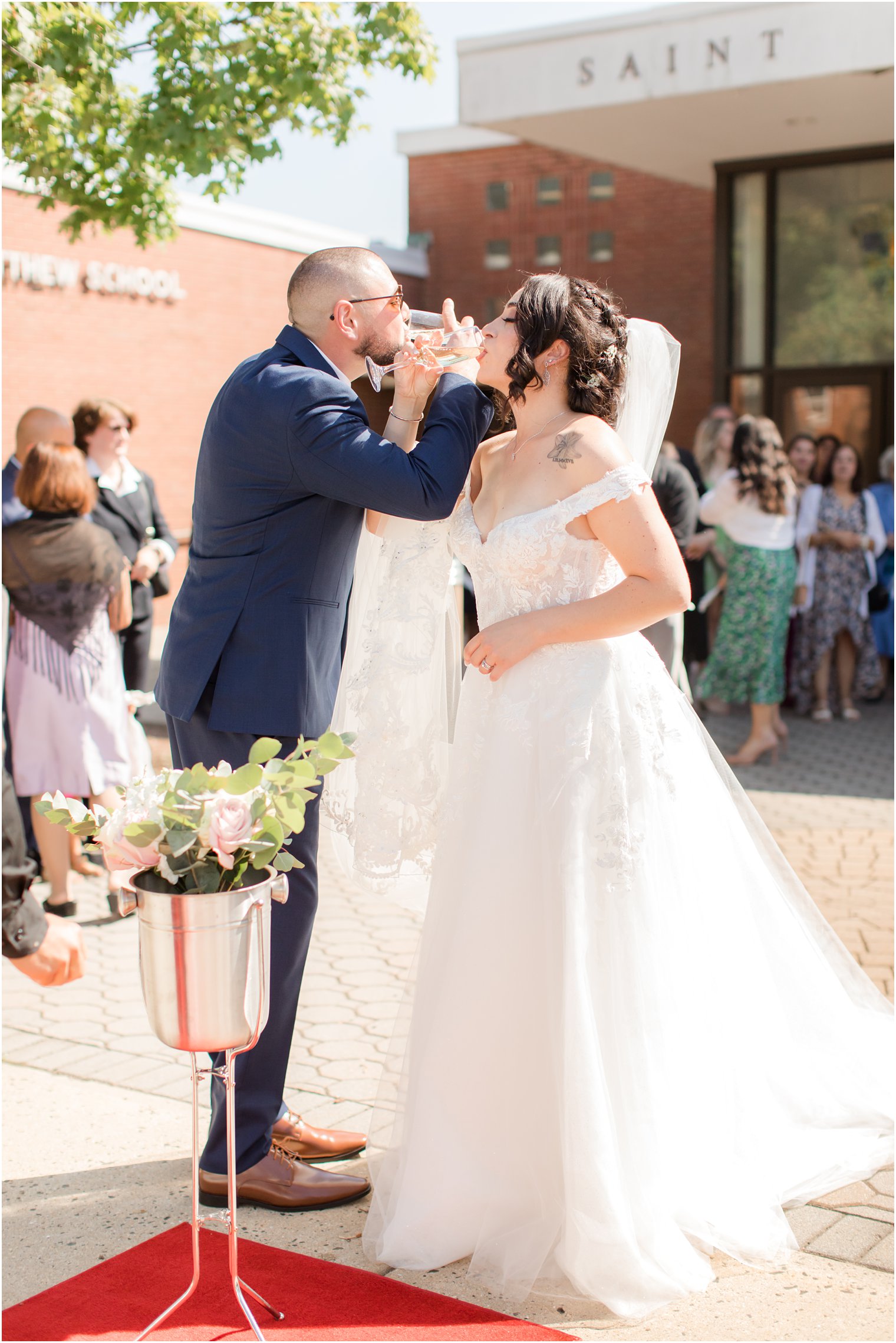 bride and groom drink champagne linking arms outside NJ wedding ceremony