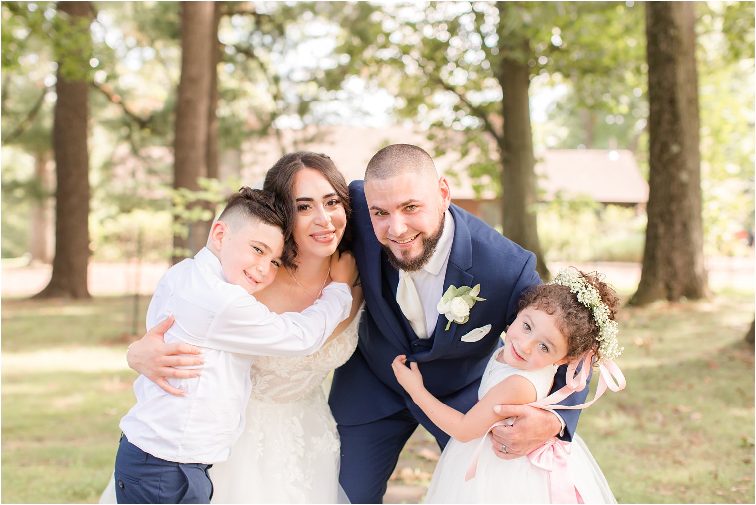 bride and groom hug their children during NJ wedding day