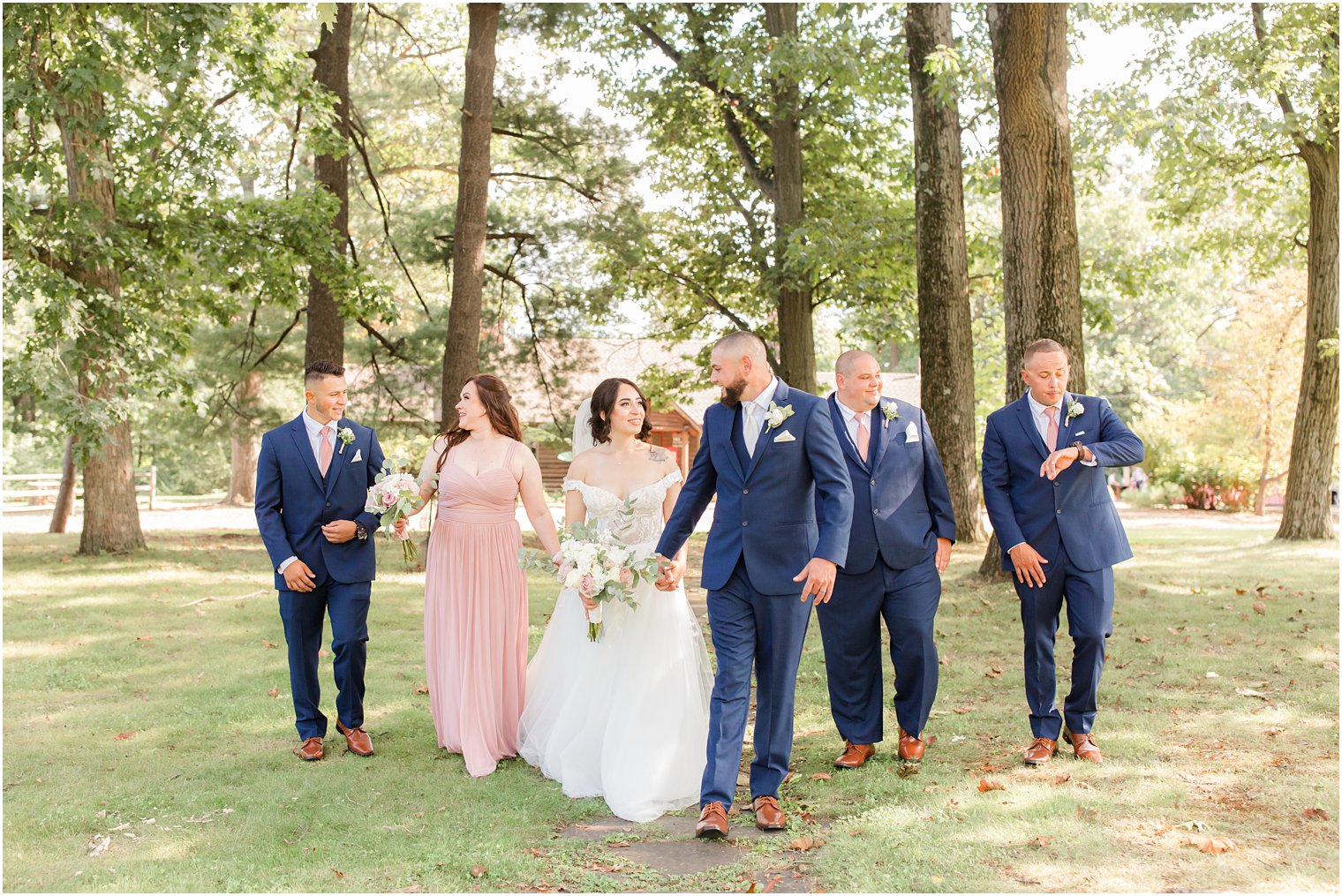 bride and groom walk with bridal party at Rutgers Gardens