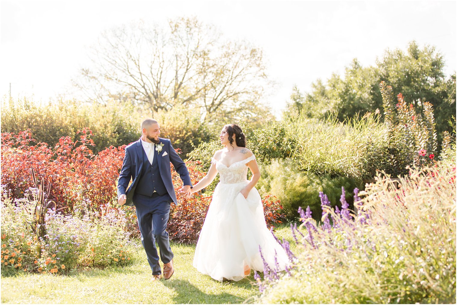 newlyweds walk through gardens at Rutgers Gardens