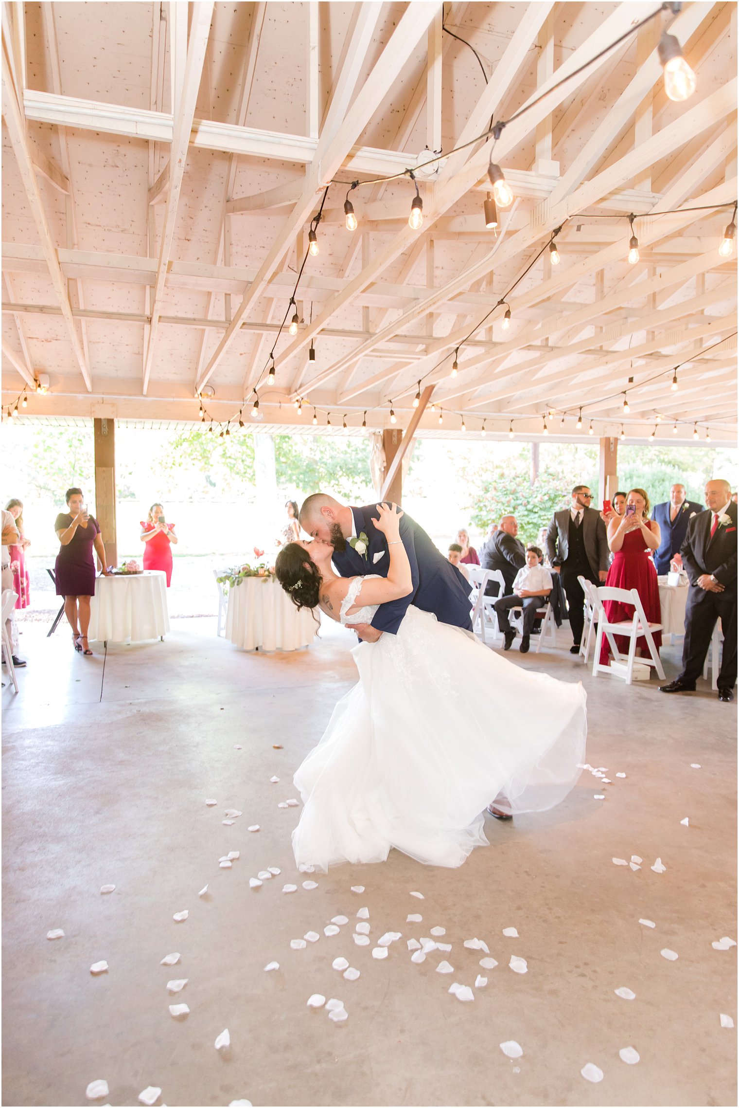 groom dips bride during first dance at Rutgers Gardens