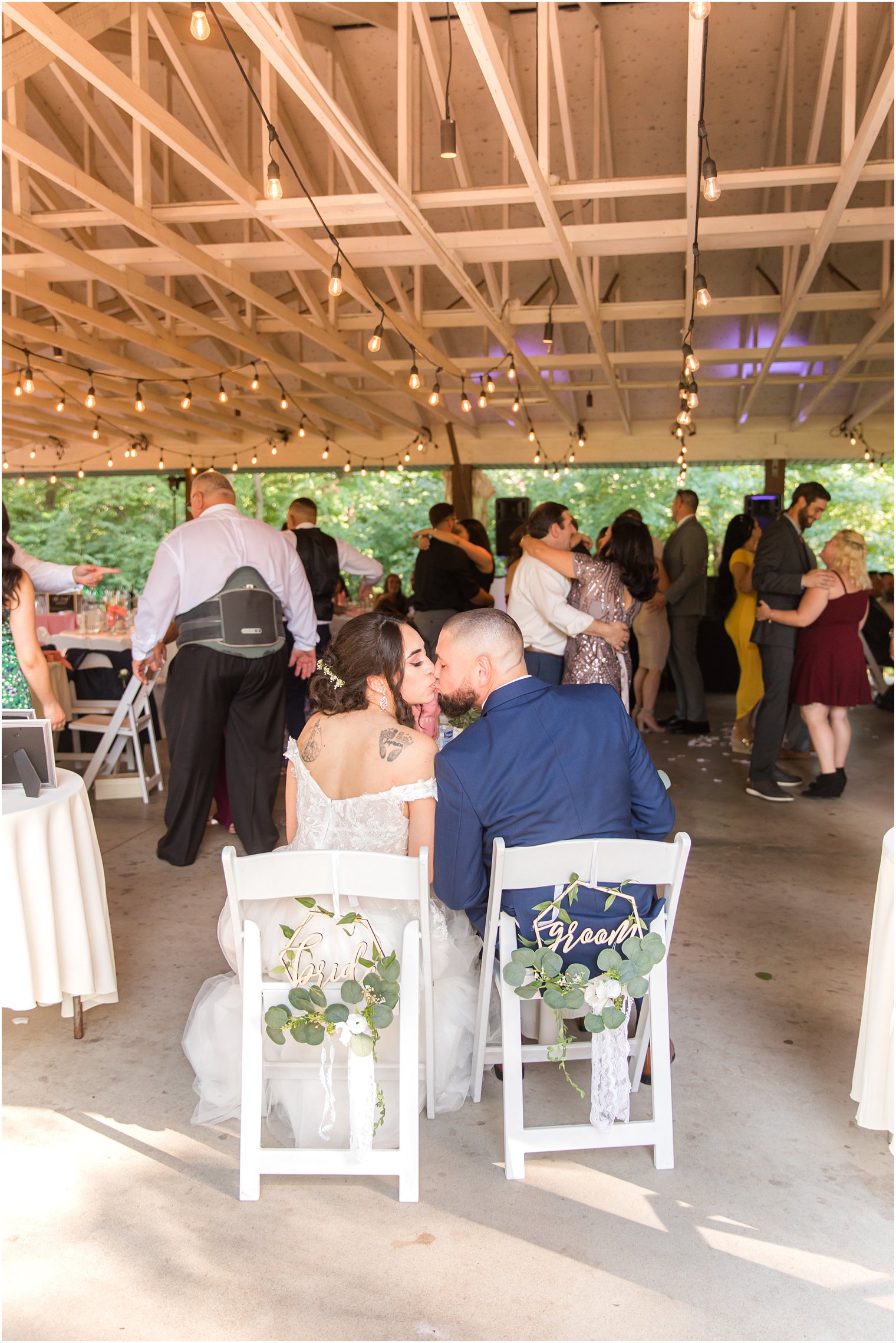 bride and groom kiss at sweetheart table during NJ wedding reception 