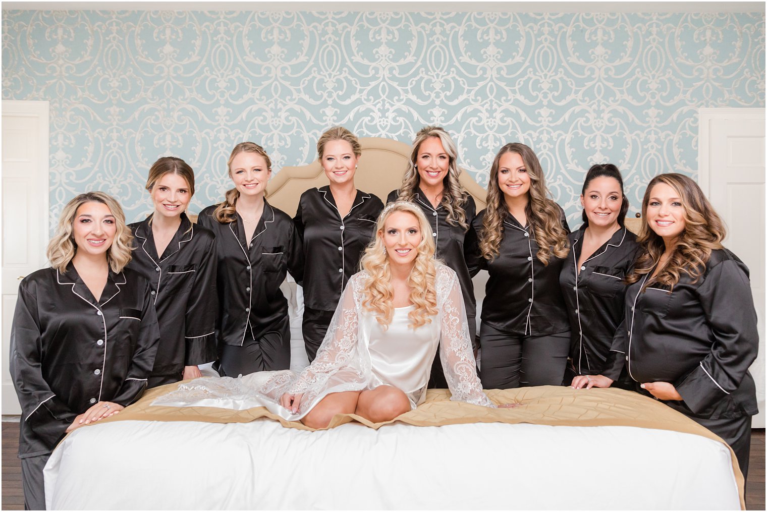 bride poses with bridesmaids in matching silk pajamas