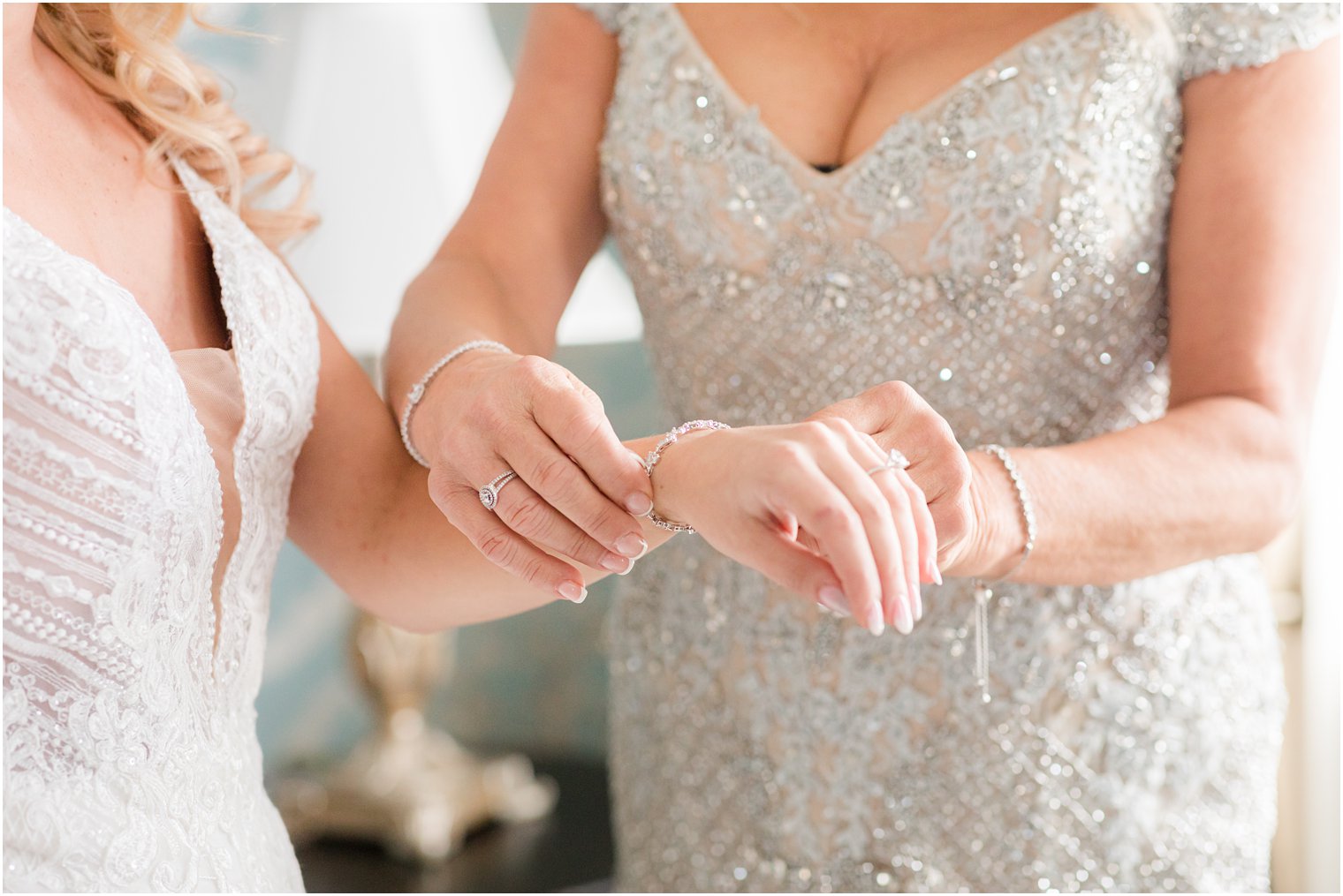 mother helps bride with bracelet on the morning of her wedding