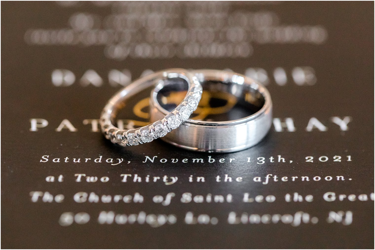 wedding bands rest on black and gold invitation for timeless wedding at the Molly Pitcher Inn
