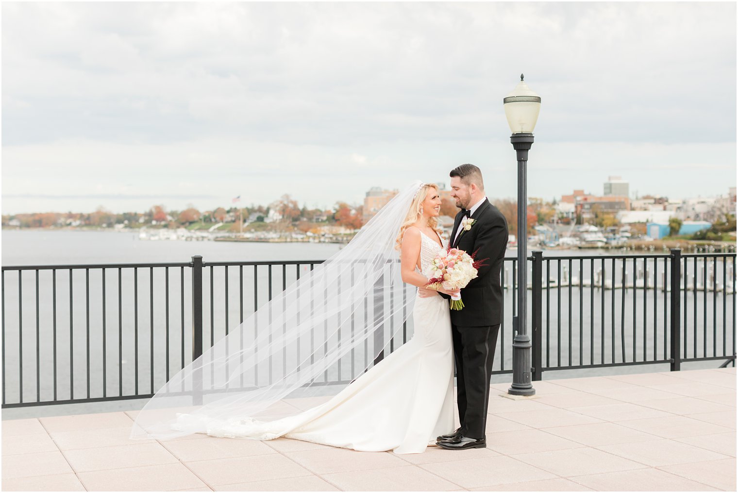 groom smiles down at bride with her veil behind them in Red Bank NJ