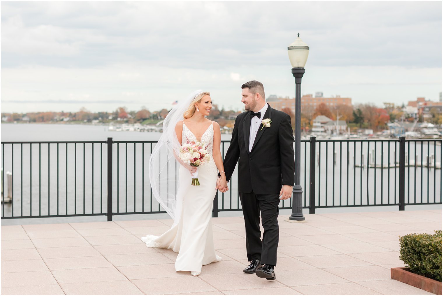bride and groom hold hands walking on patio at the Molly Pitcher Inn