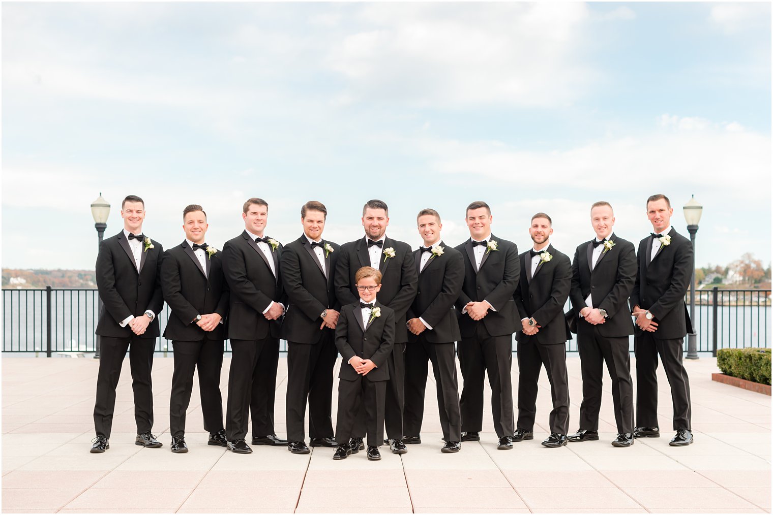 groom and groomsmen stand in black tuxes with ring bearer outside the Molly Pitcher Inn