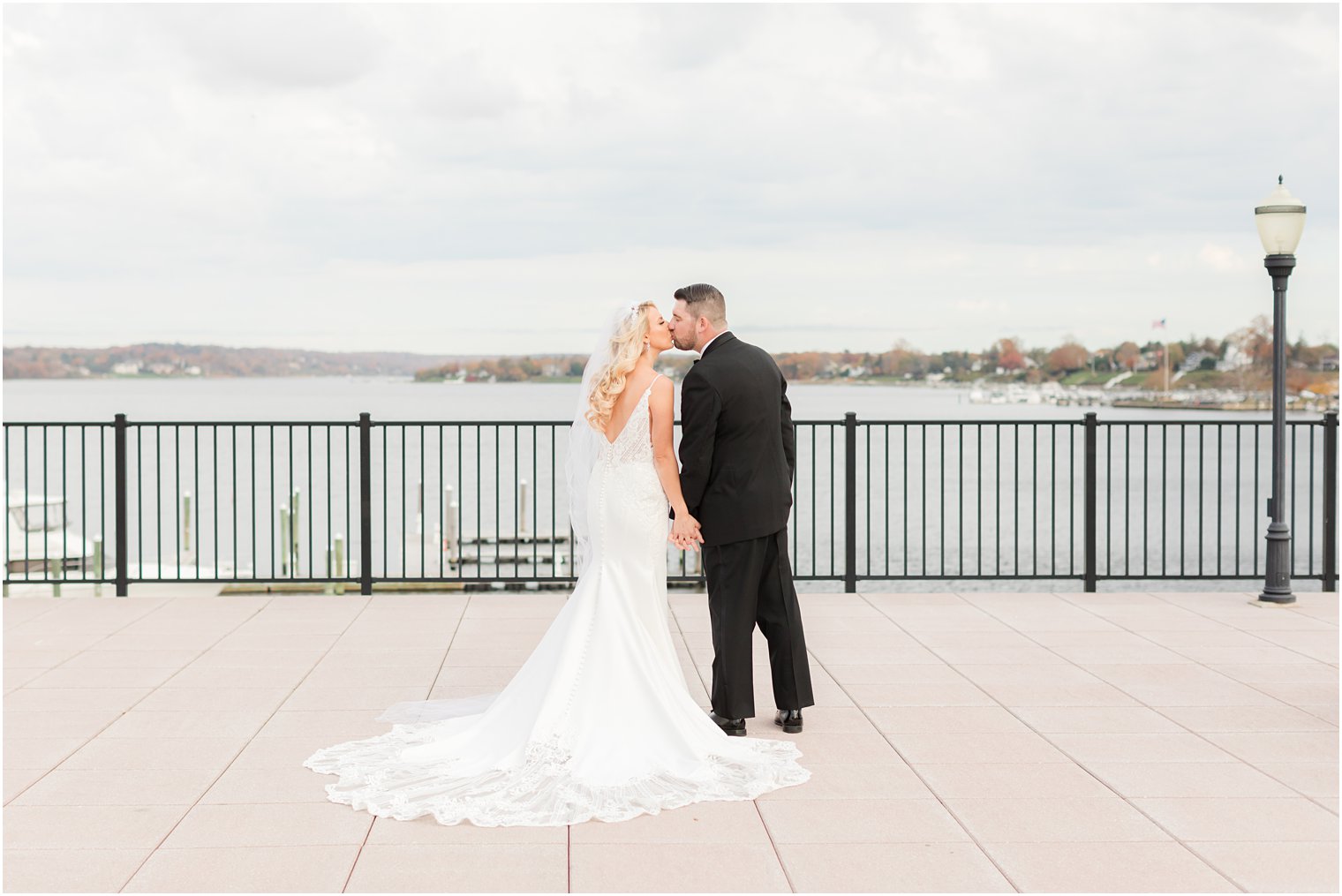 newlyweds hold hands and kiss on patio at the Molly Pitcher Inn