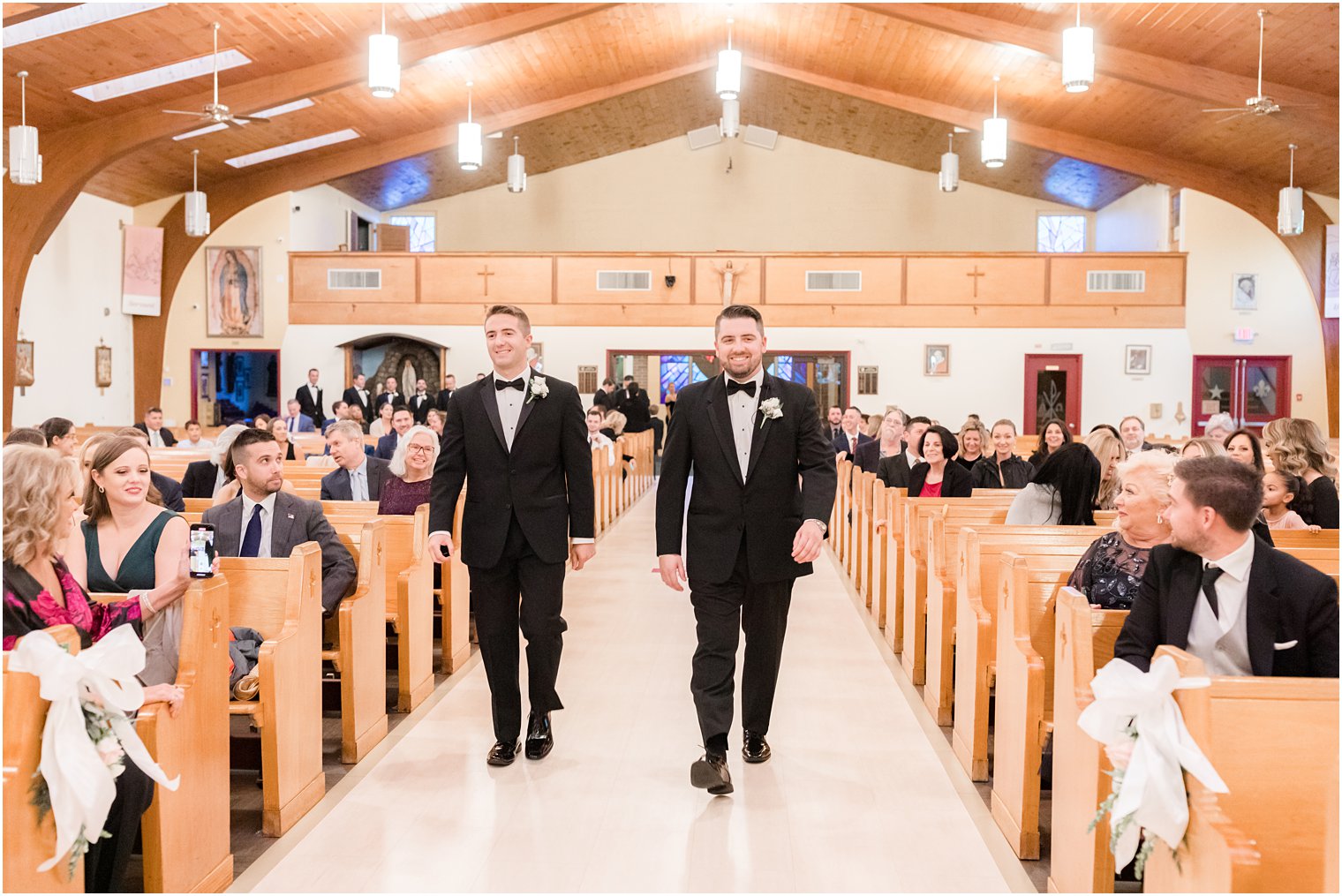 groom walks down aisle with best man for church wedding ceremony in Red Bank NJ