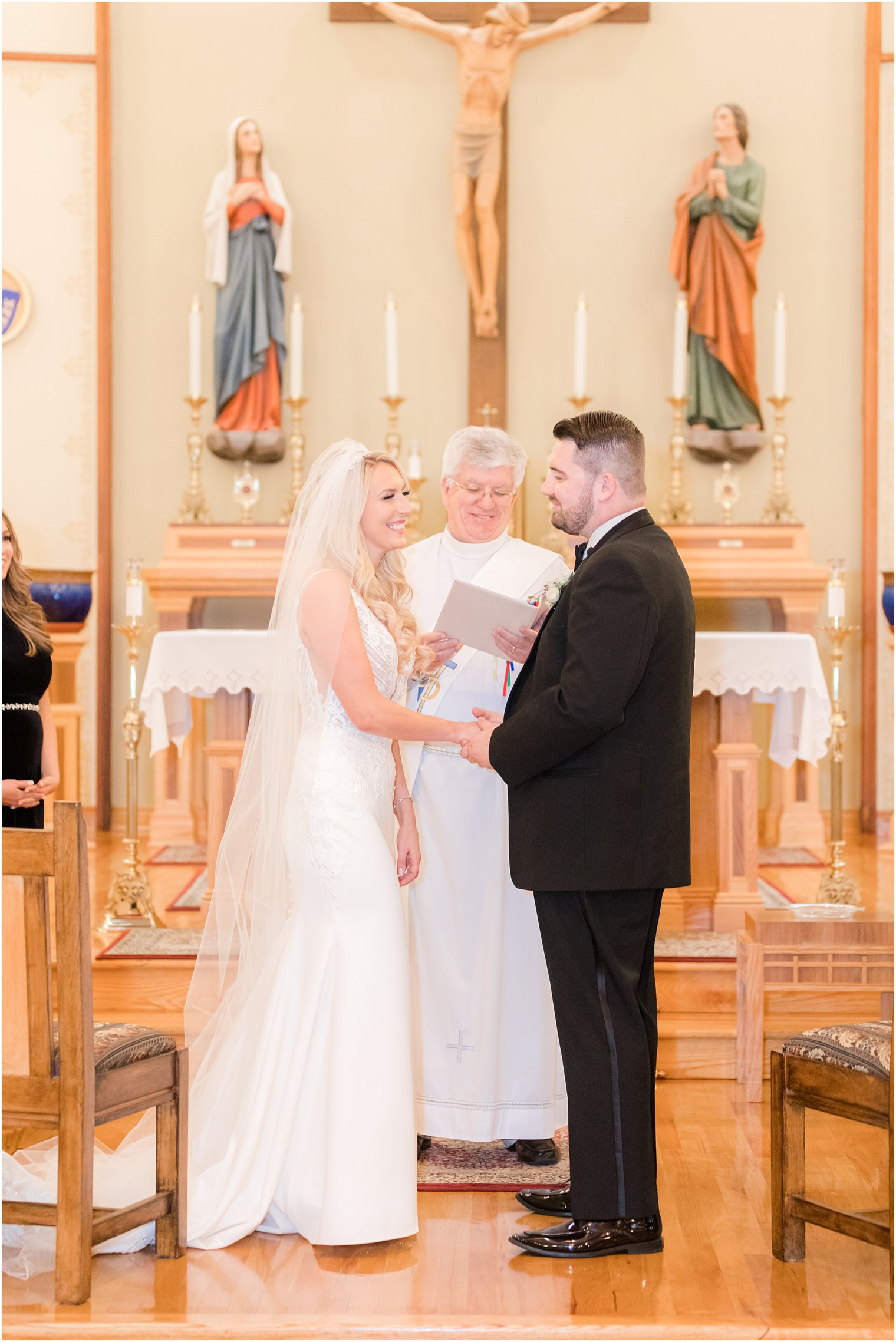 bride and groom hold hands exchanging vows during church wedding ceremony in Red Bank NJ