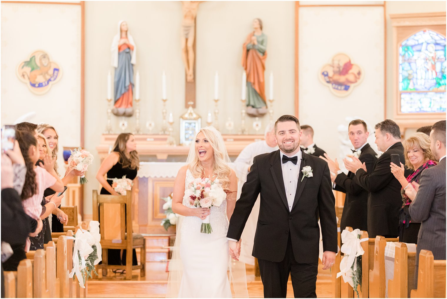bride laughs walking up aisle with groom after church wedding ceremony in New Jersey