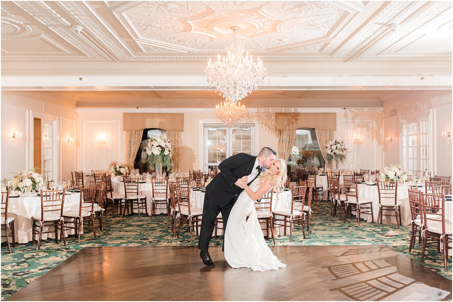 groom kisses bride's cheek dipping her in ballroom at Molly Pitcher Inn