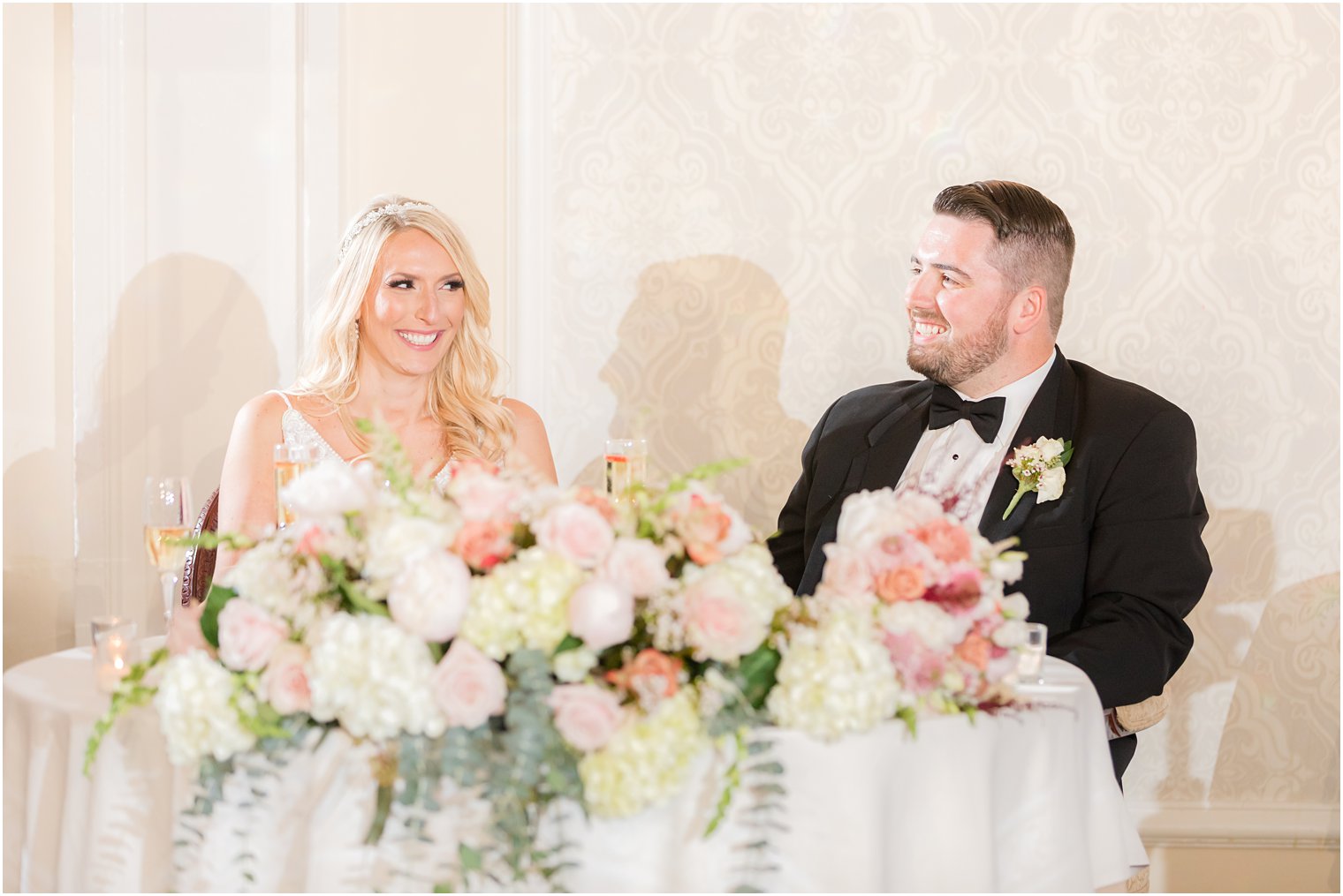 newlyweds smile together at head table during Red Bank NJ wedding reception